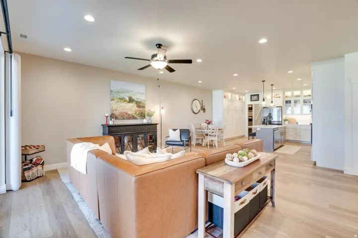 Open-concept living space featuring light wood-finish flooring, recessed lighting, and a ceiling fan