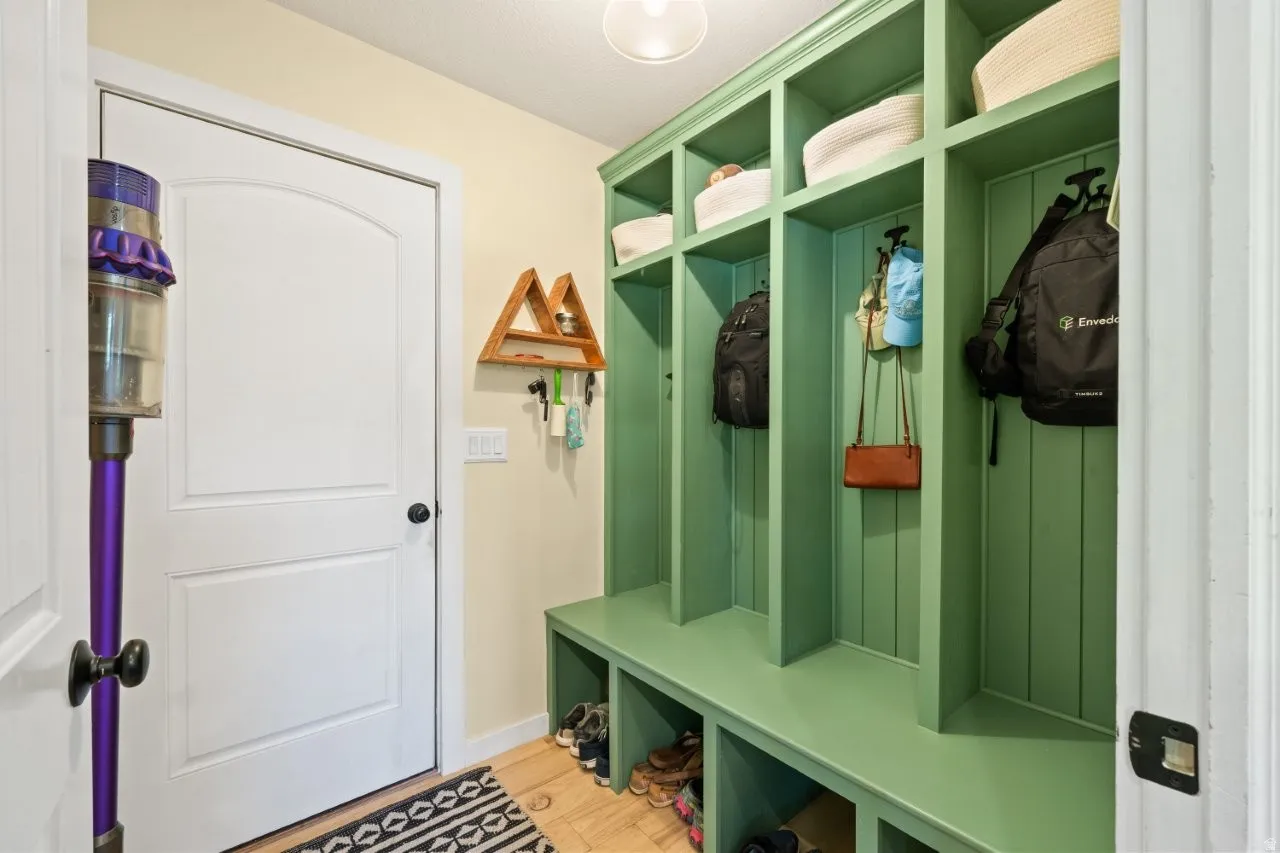 Built-in mudroom storage featuring individual cubbies, upper shelving, and a bench seating area