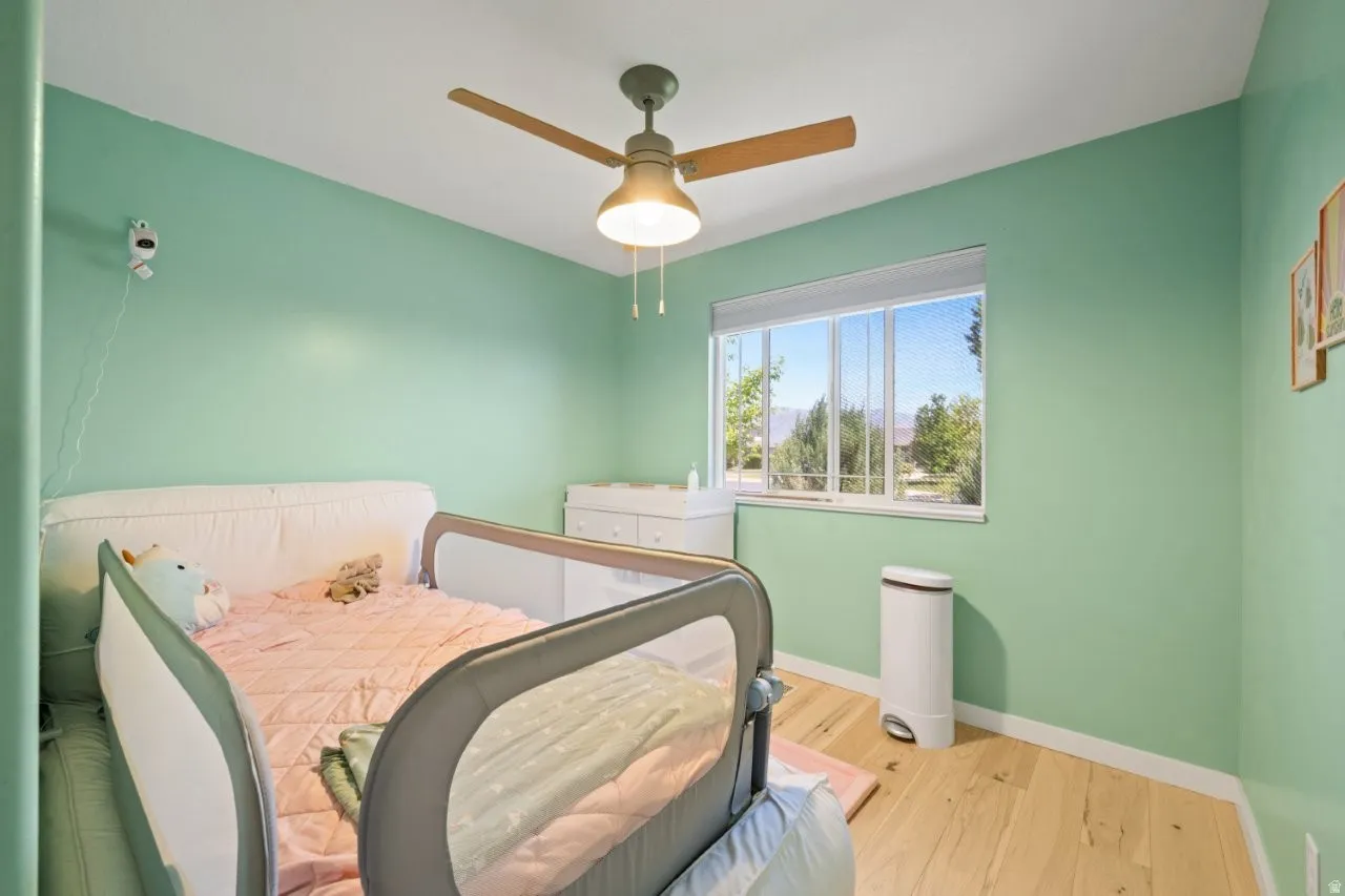 Light-toned wood-finish flooring complements the room's soft green walls