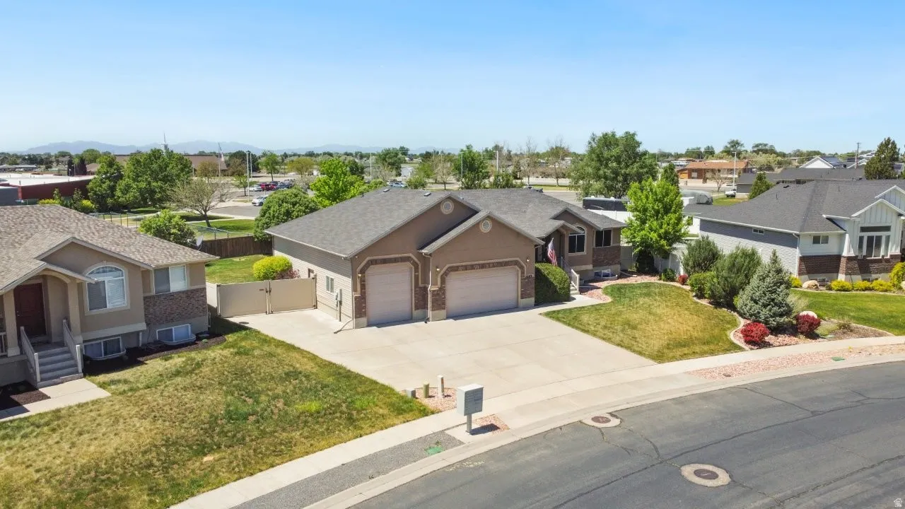 Neutral-toned exterior with a multi-car driveway, two-car garage, and established landscaping