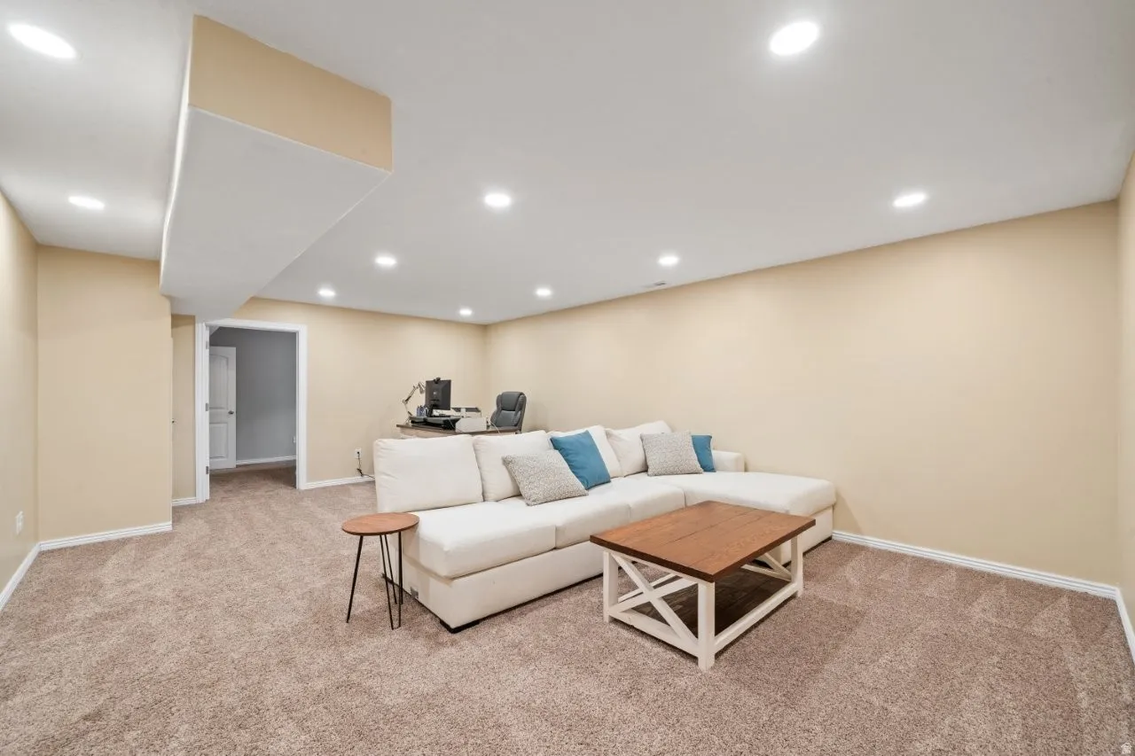 Spacious interior room featuring light beige walls and recessed ceiling lights