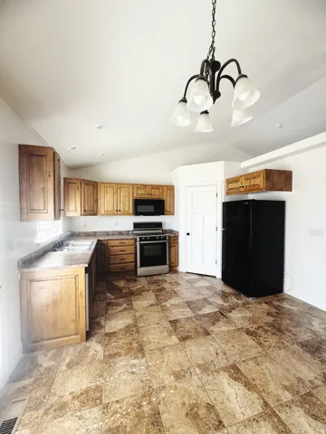 Kitchen featuring wood cabinetry, laminate countertops, and stainless steel appliances including an oven and microwave
