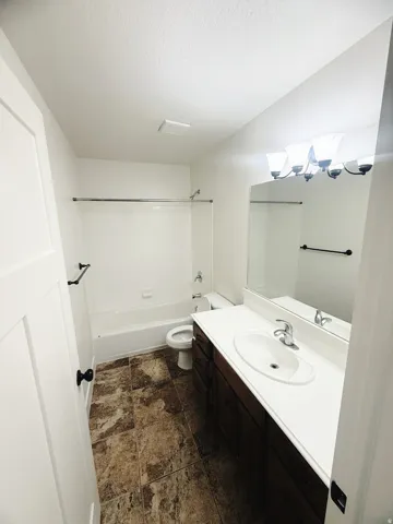 Full bathroom featuring a single vanity with a white countertop, undermount sink, and dark wood-finish cabinetry