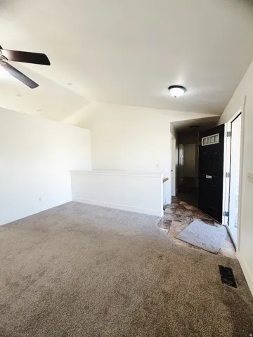 Spacious living area featuring vaulted ceilings, recessed lighting, and a ceiling fan