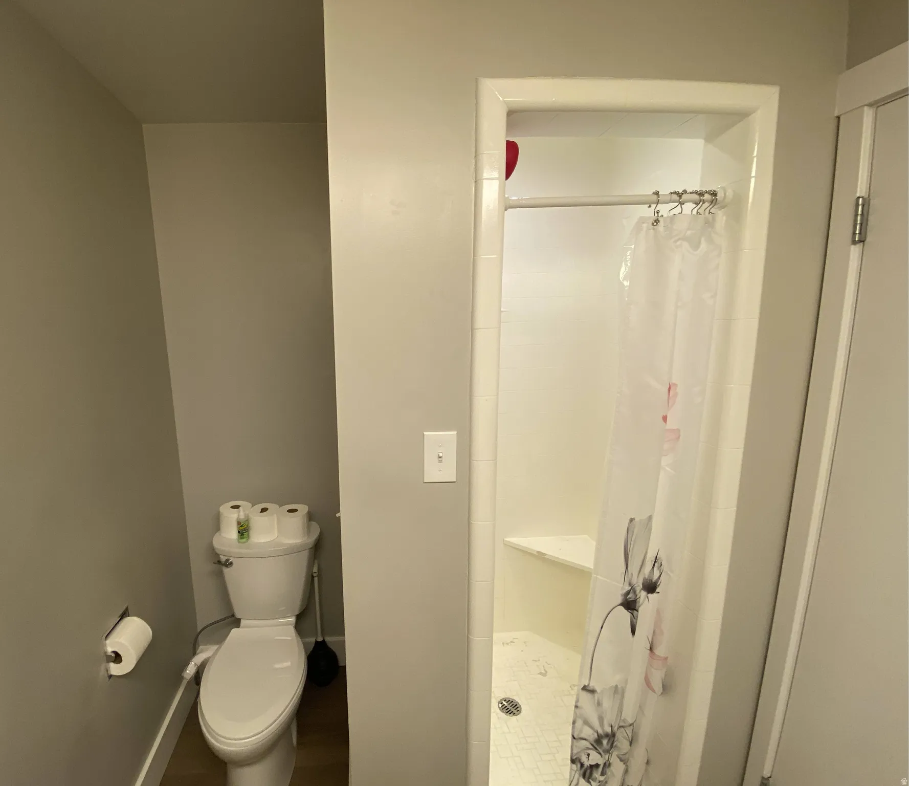 Walk-in shower with white tile surround and a built-in corner seat