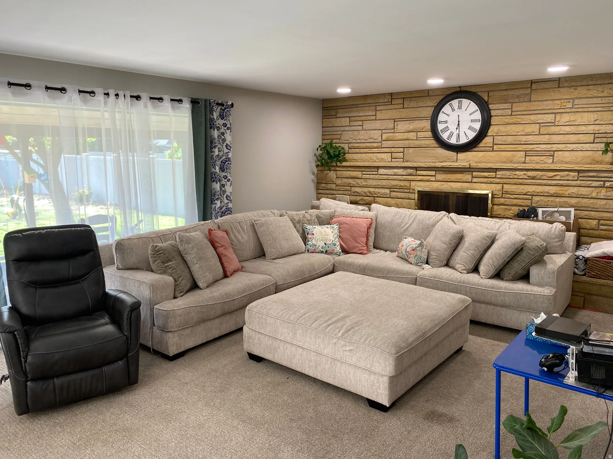 Living area featuring a stone accent wall with a fireplace