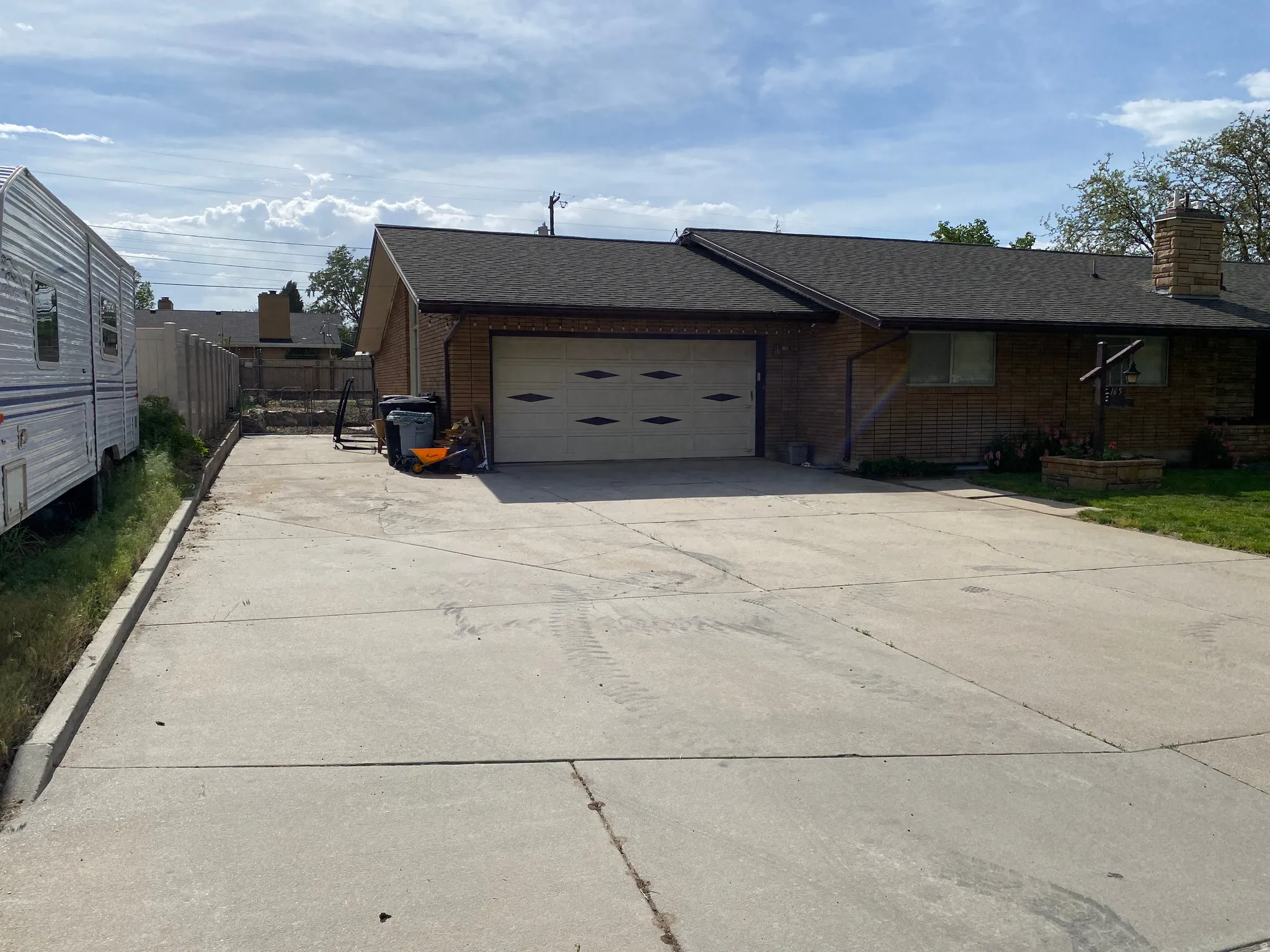 Brick exterior home with a two-car garage, concrete driveway, and dark shingle roof