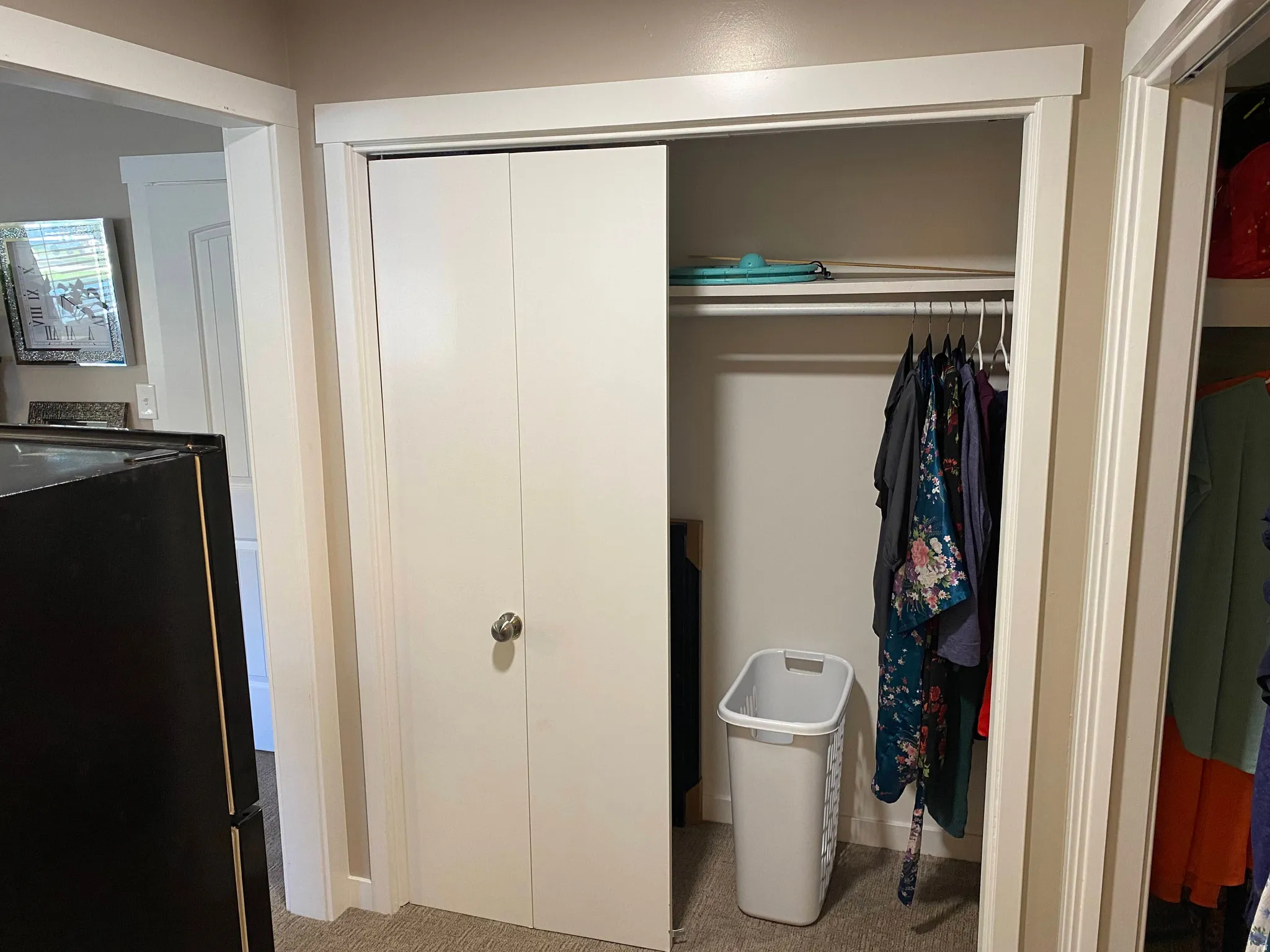 Bi-fold closet doors with brushed nickel hardware, featuring an interior hanging rod and upper shelf storage
