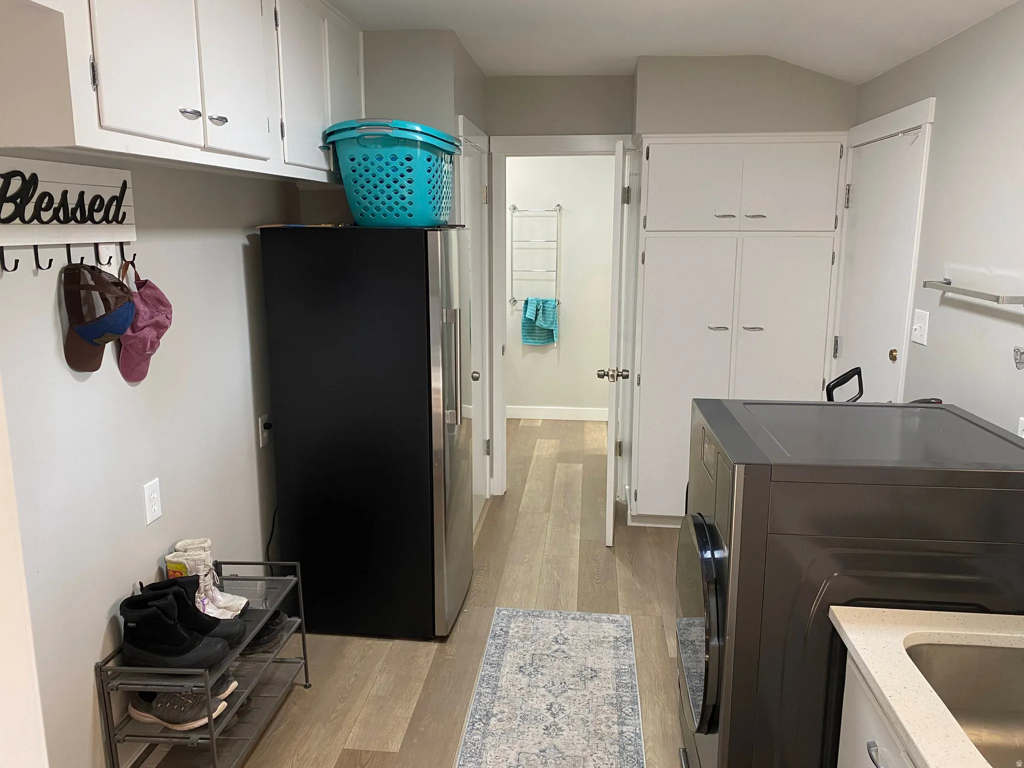 Dedicated utility space featuring light wood-finish flooring and light gray walls