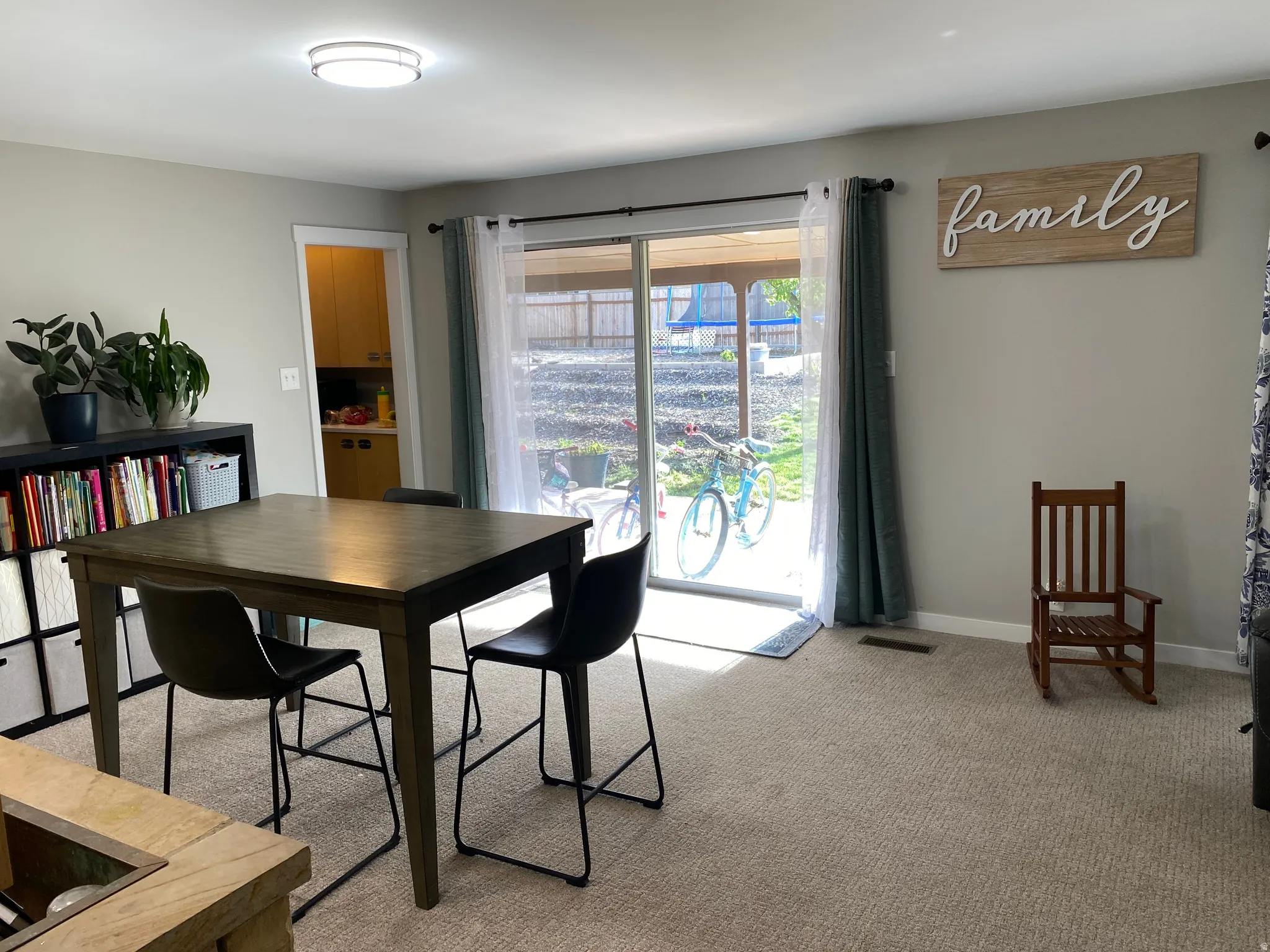Carpeted open-concept room with a sliding glass door providing outdoor access