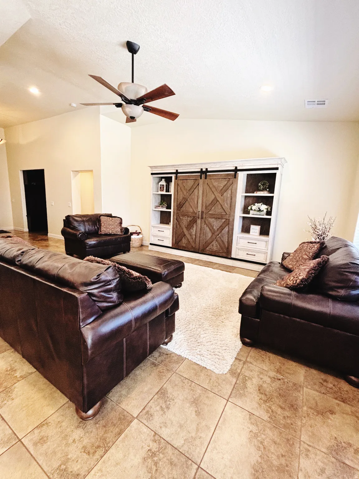 Vaulted ceilings feature a ceiling fan with wood-finish blades
