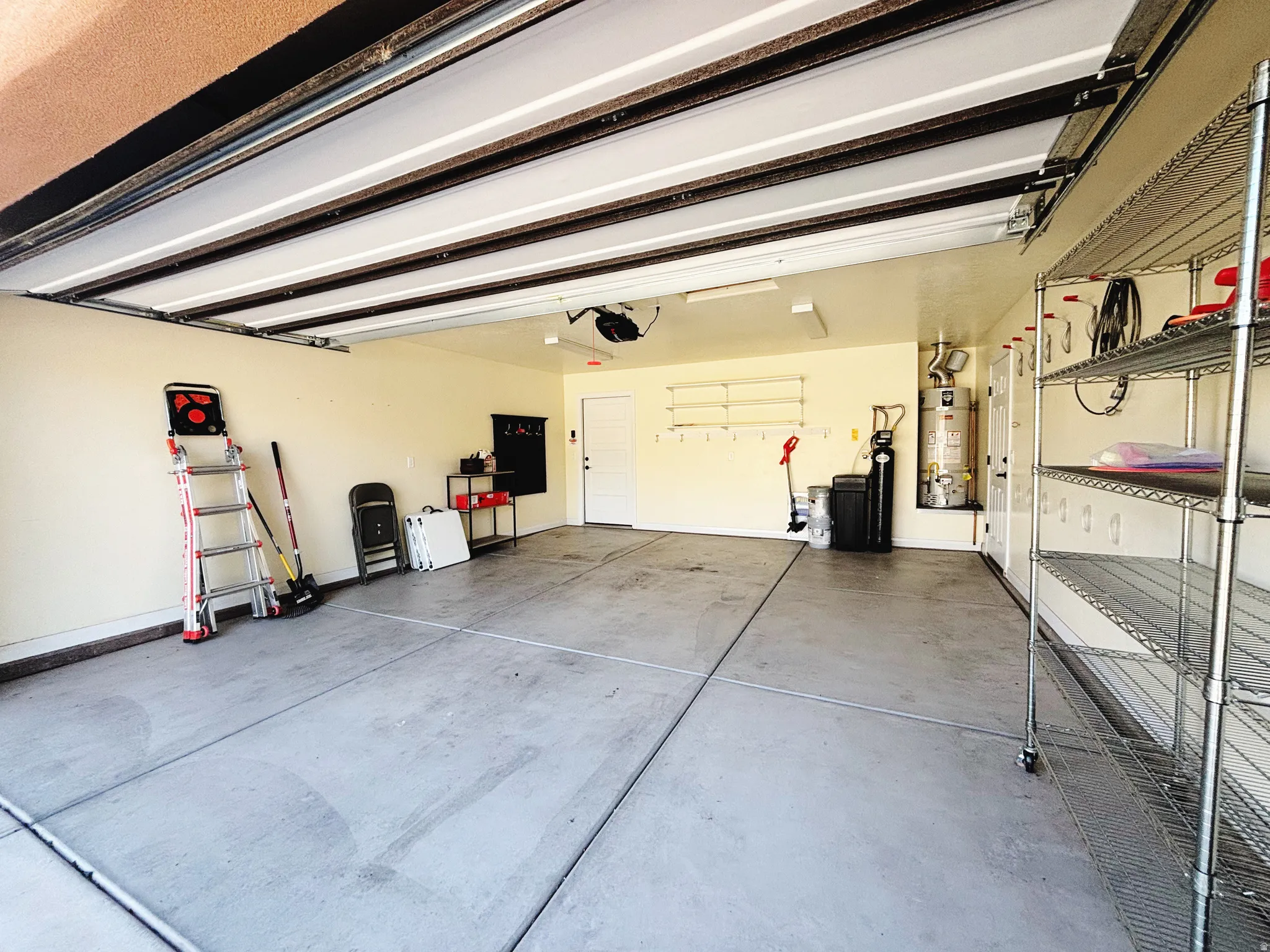 Spacious garage featuring concrete flooring and a white overhead garage door