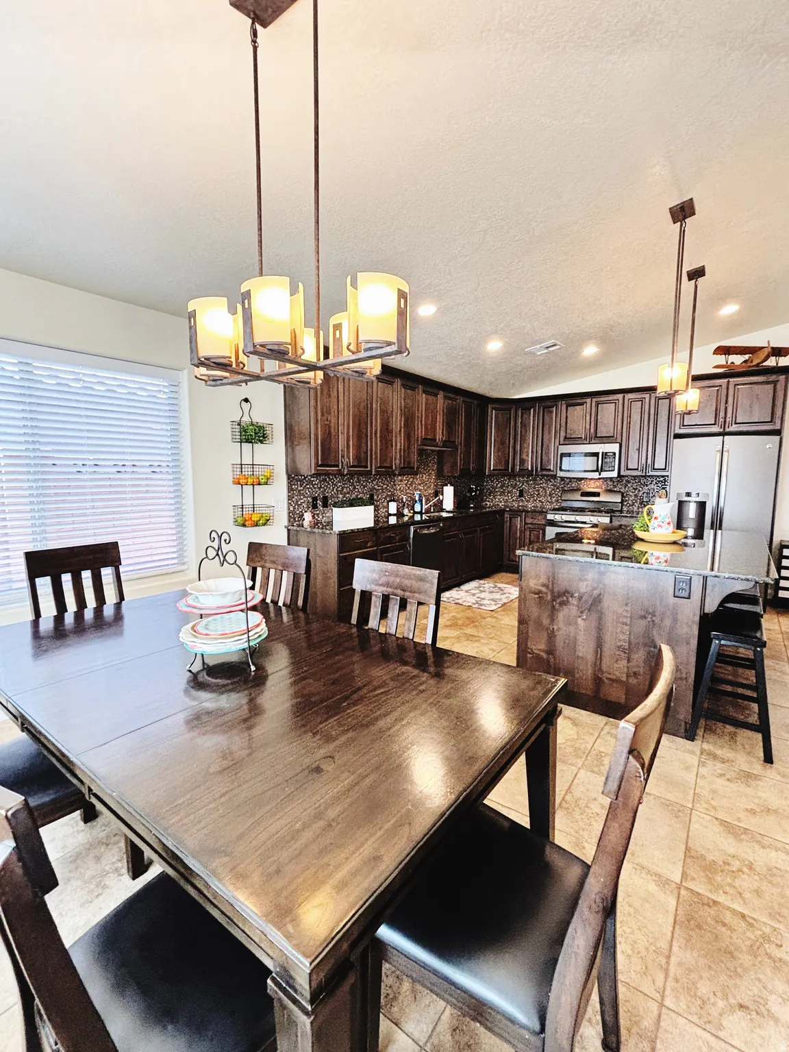 Dining area featuring a contemporary chandelier with a kitchen beyond