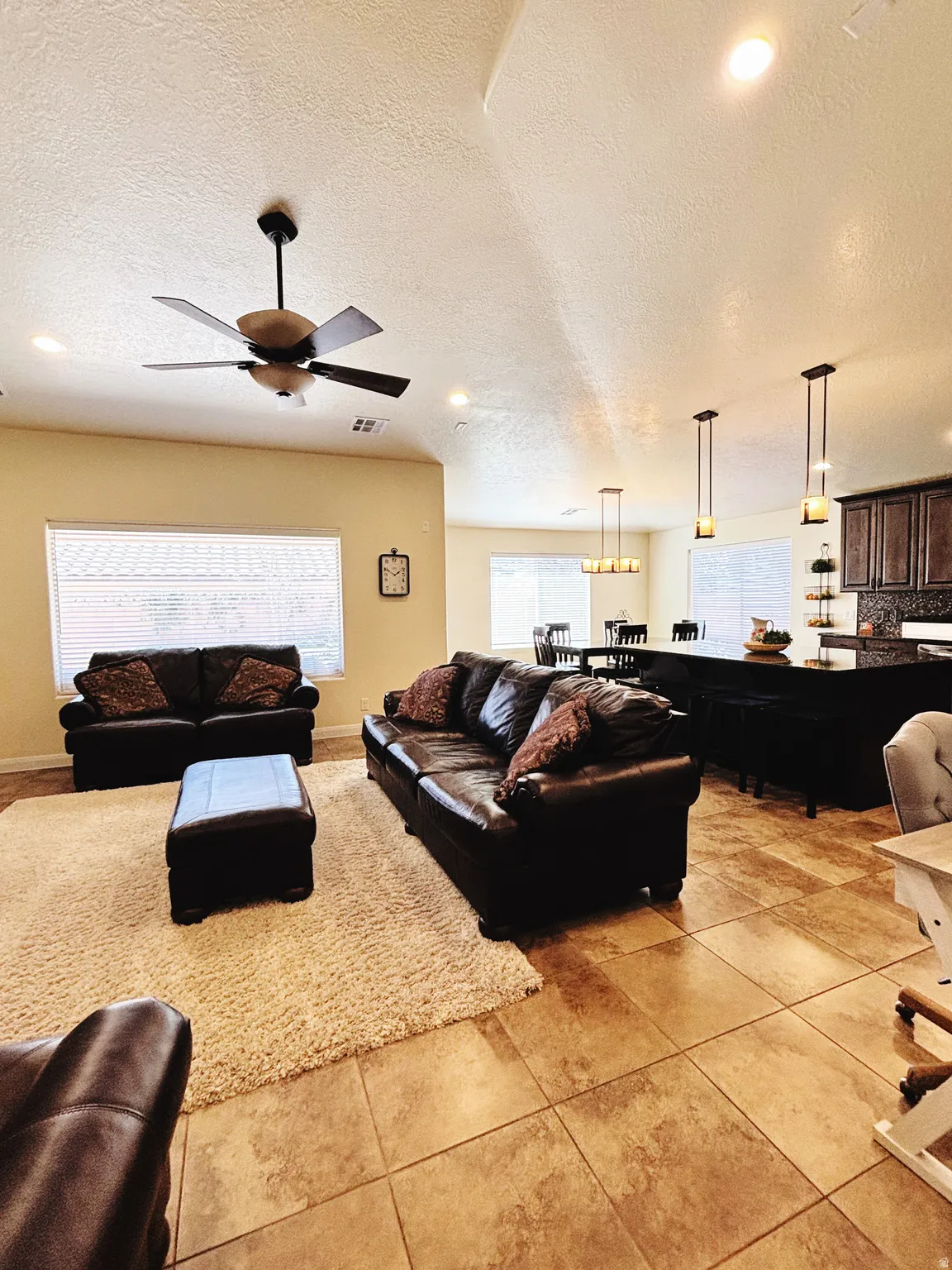 Open-concept living space featuring tile flooring and recessed lighting
