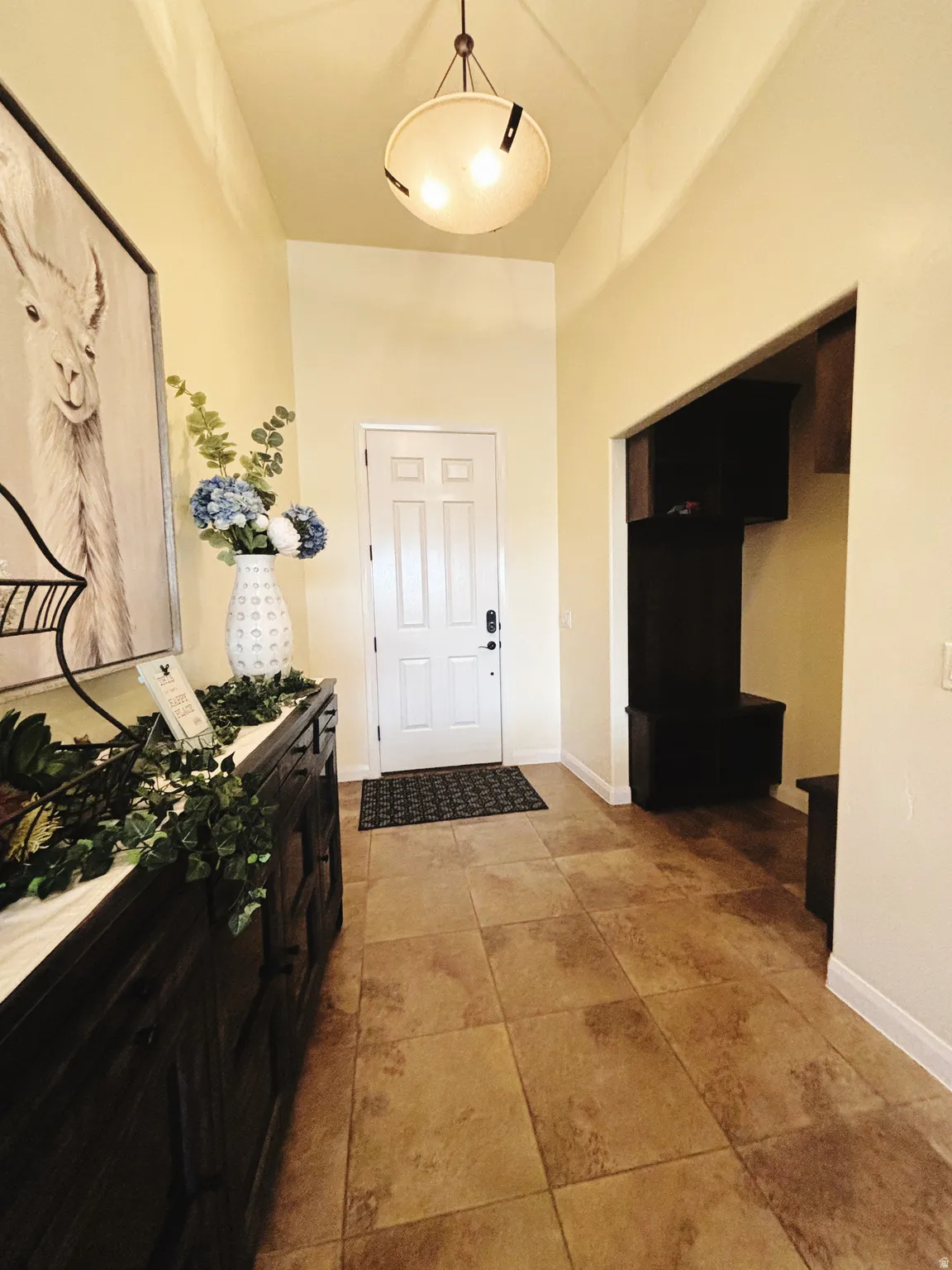Foyer with tile flooring, a white paneled entry door, and a domed ceiling light fixture