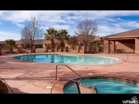 Resort-style pool area featuring a large swimming pool, integrated spa, and expansive paved decking