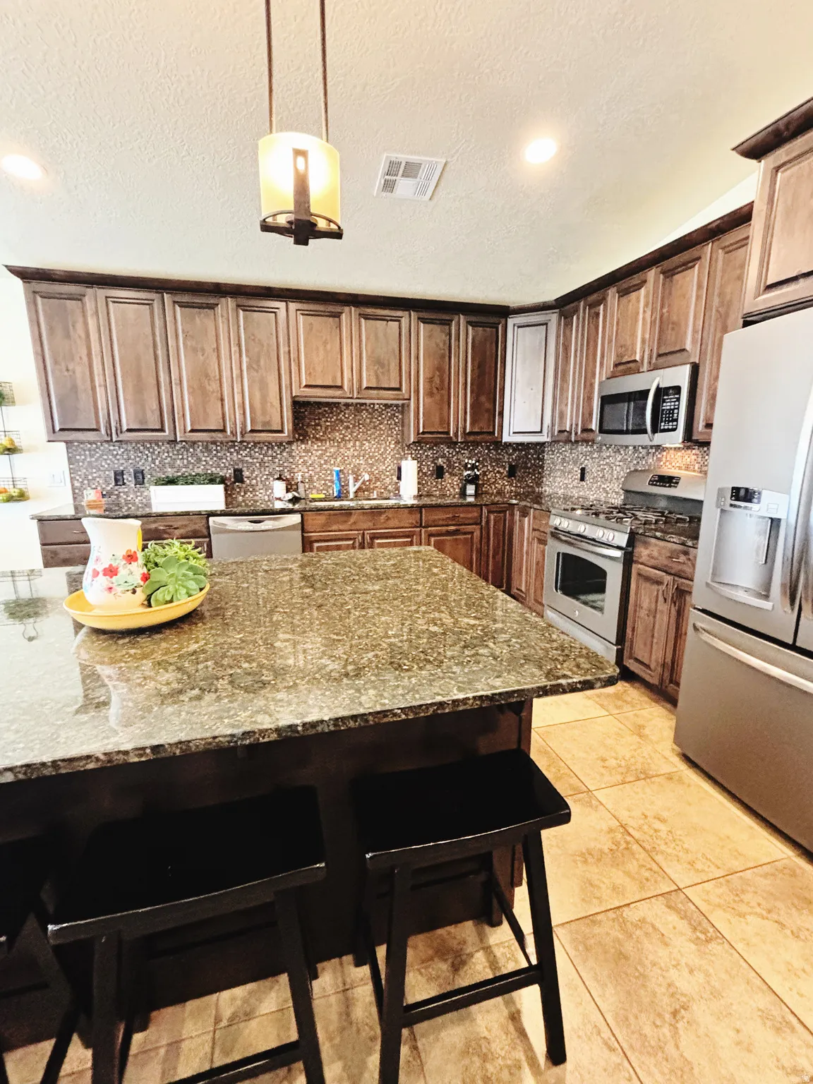 Kitchen island featuring a substantial granite countertop