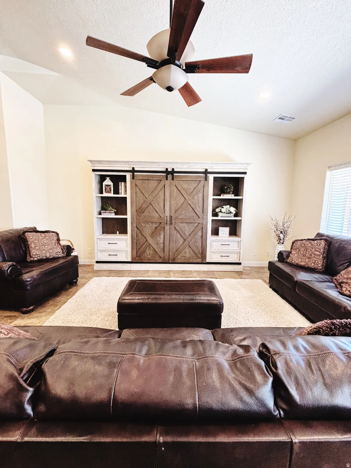 Vaulted ceilings featuring a ceiling fan with integrated lighting