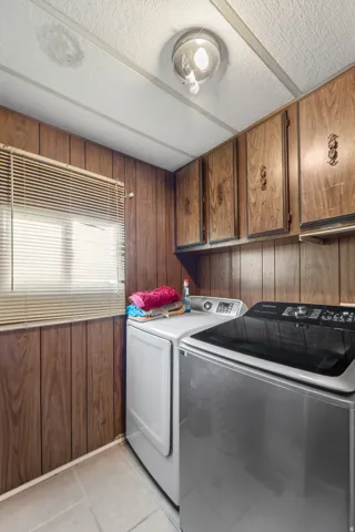 Dedicated laundry area with wood-finish wall paneling