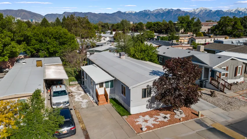 Single-story residence featuring light gray siding, a covered carport, and a low-maintenance front yard with decorative rock landscaping