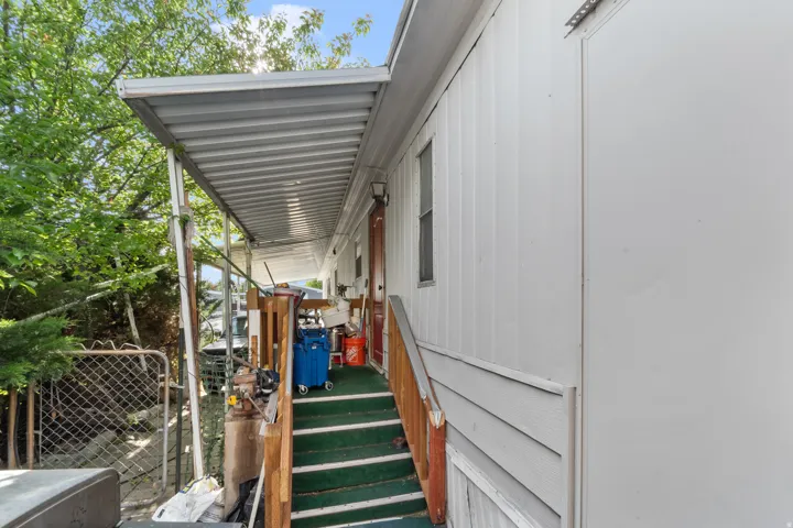 Covered porch with metal roofing, wood railing, and carpeted steps