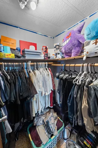 Walk-in closet featuring built-in shelving, hanging rods, and a ceiling-mounted light fixture