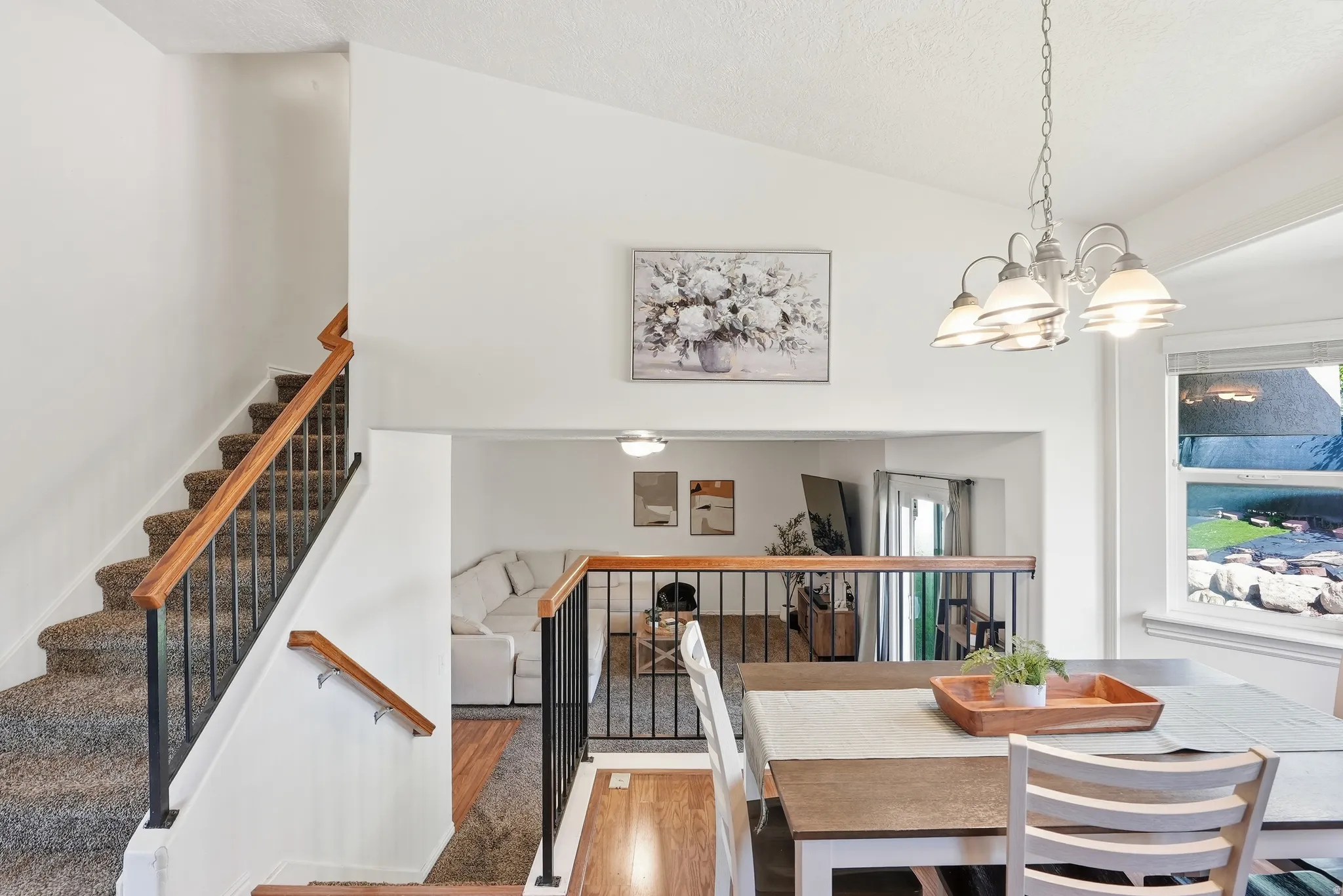 Dining area featuring a contemporary chandelier, large window, and wood-finish flooring