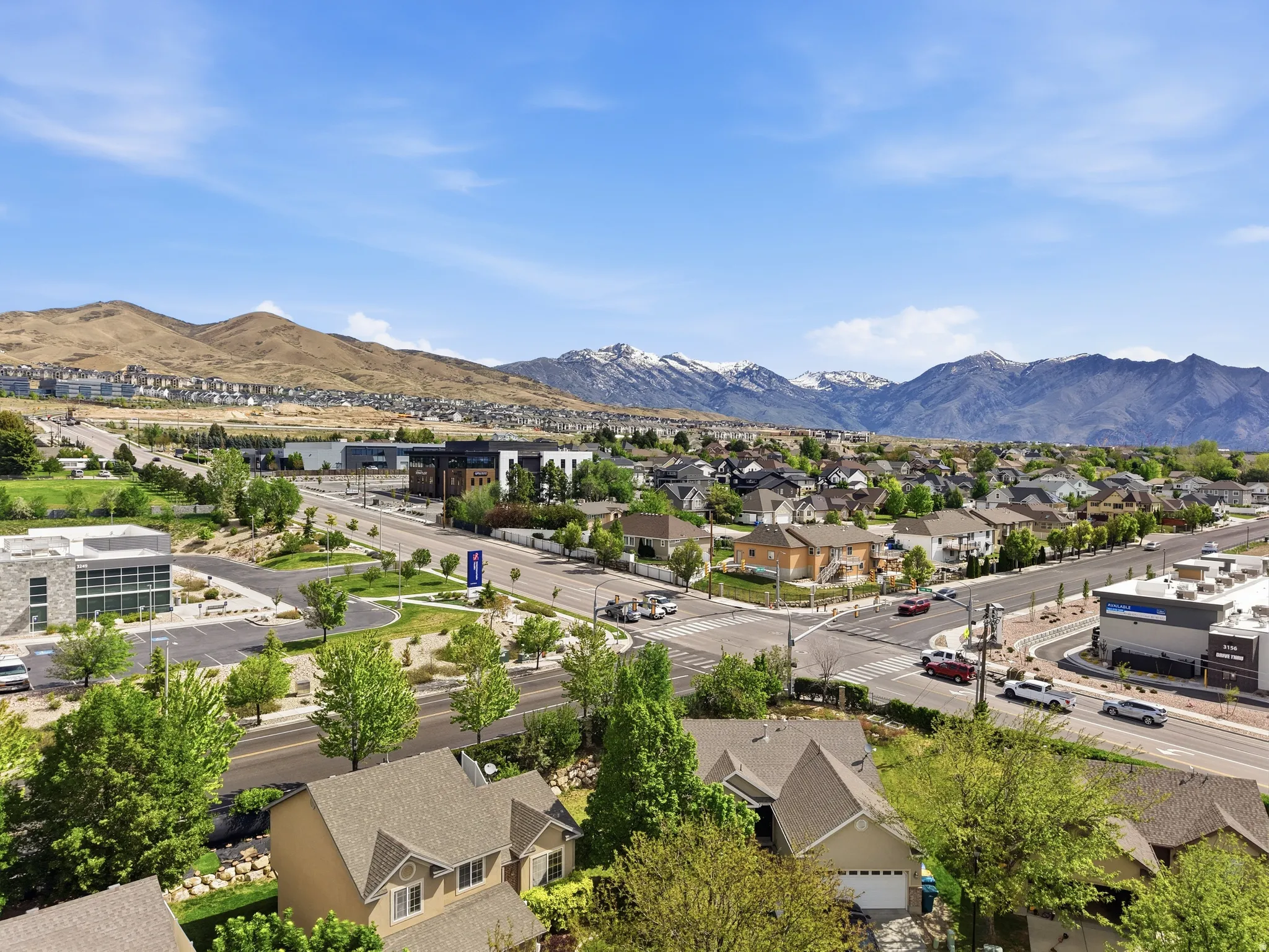 Expansive aerial showcasing a residential community with distant mountain ranges