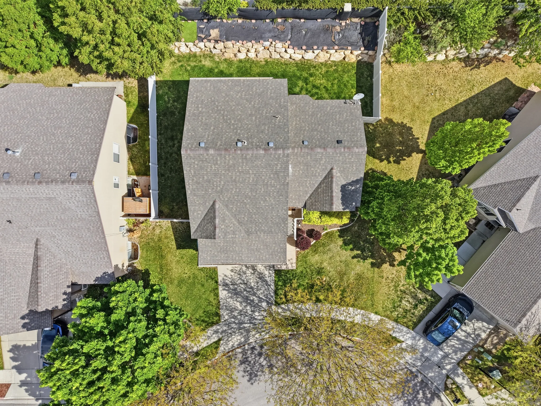Aerial view showcasing the property’s architectural design, surrounding green spaces, and a curved driveway
