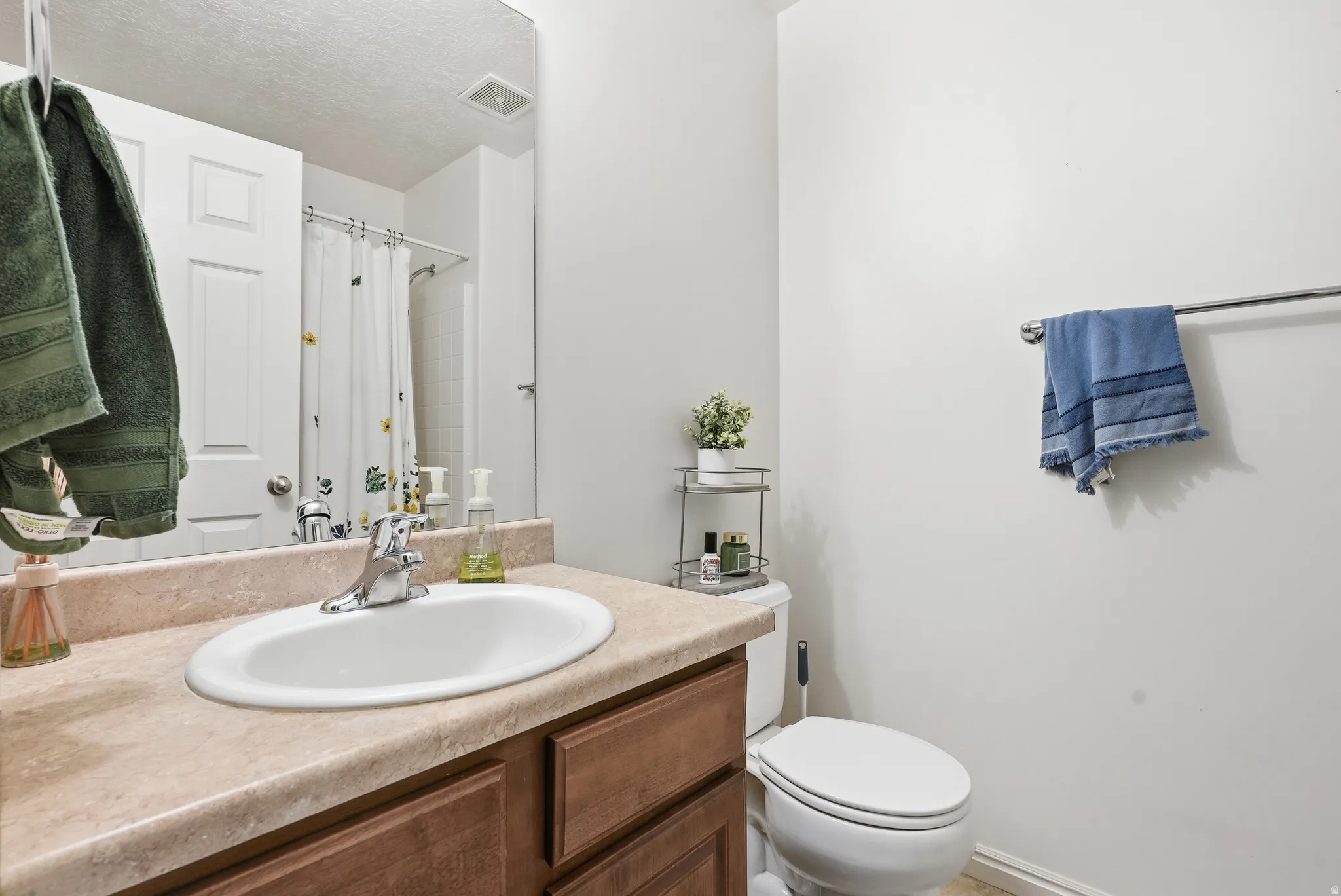Bathroom vanity with an integrated sink, laminate countertop, and wood-finish cabinetry