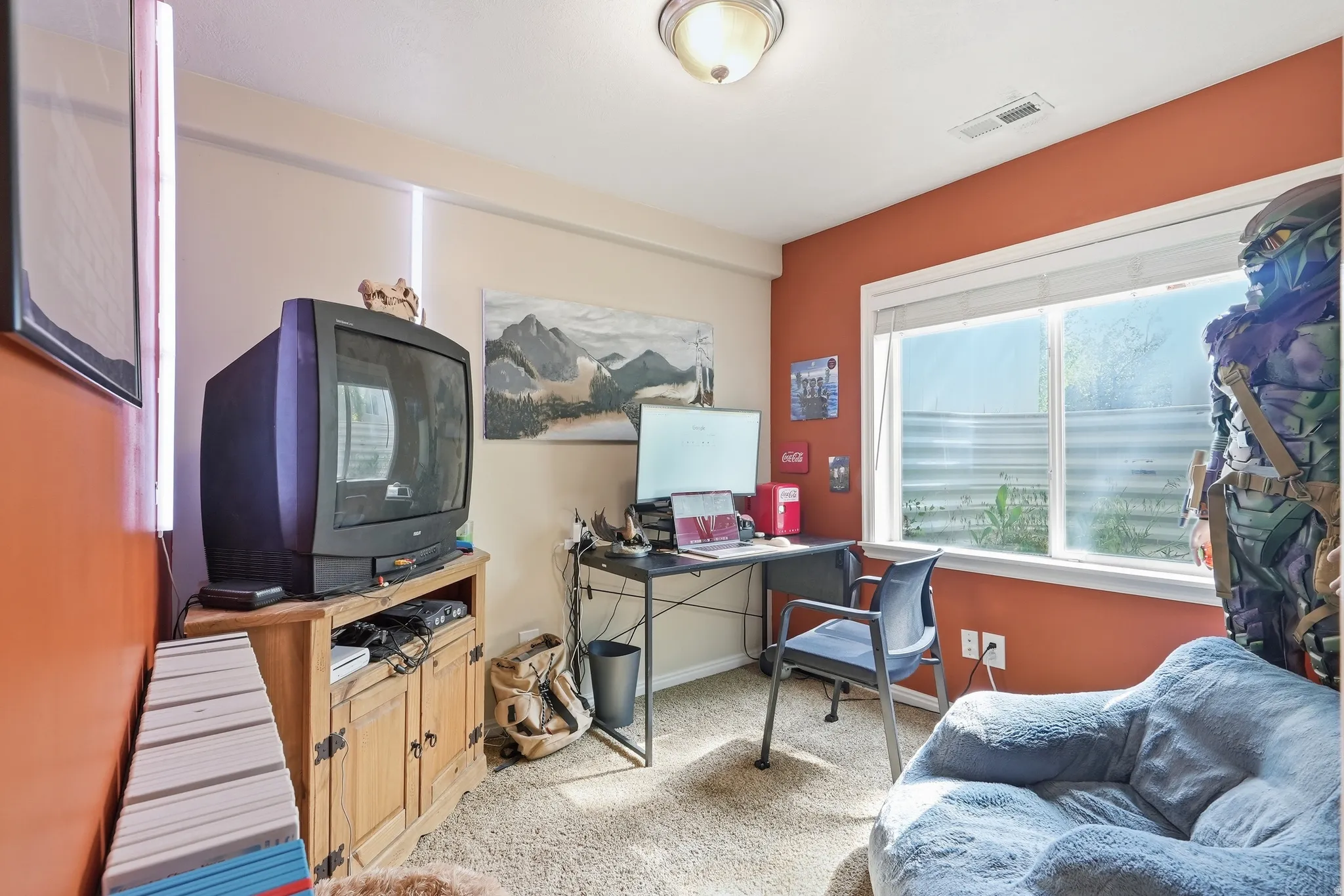 Carpeted room featuring a double-pane window, flush-mount ceiling light, and neutral wall tones with an accent wall