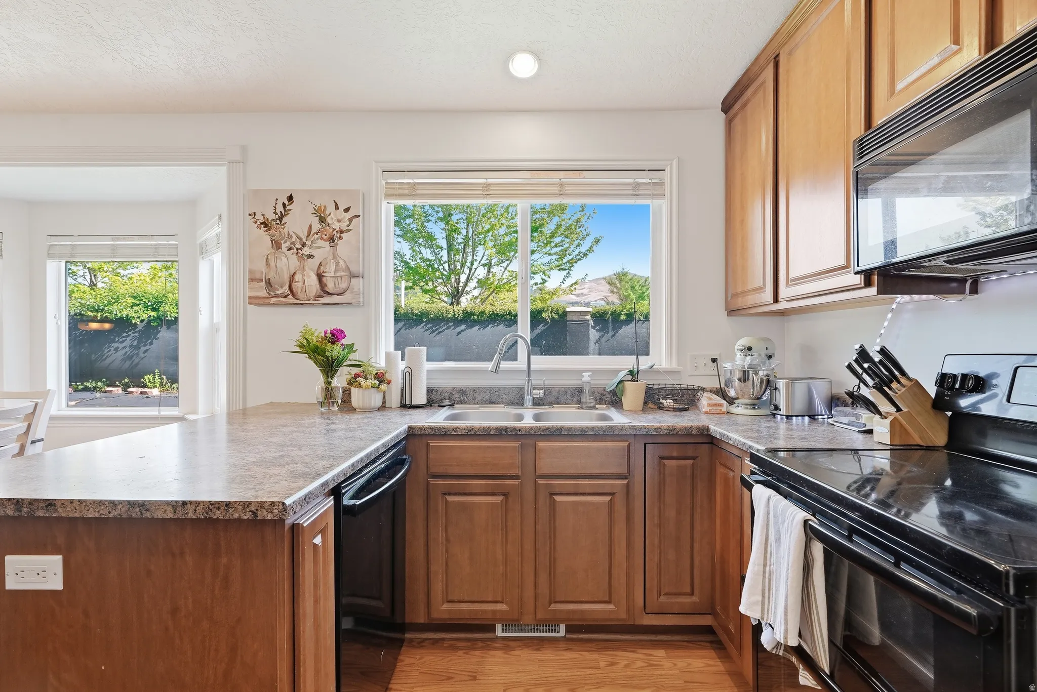 Kitchen featuring wood-finish cabinetry, stone-look countertops, and stainless steel sink