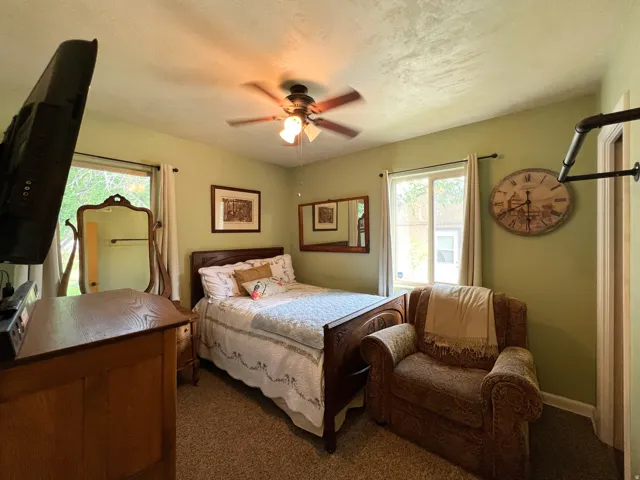 Carpeted room featuring a ceiling fan