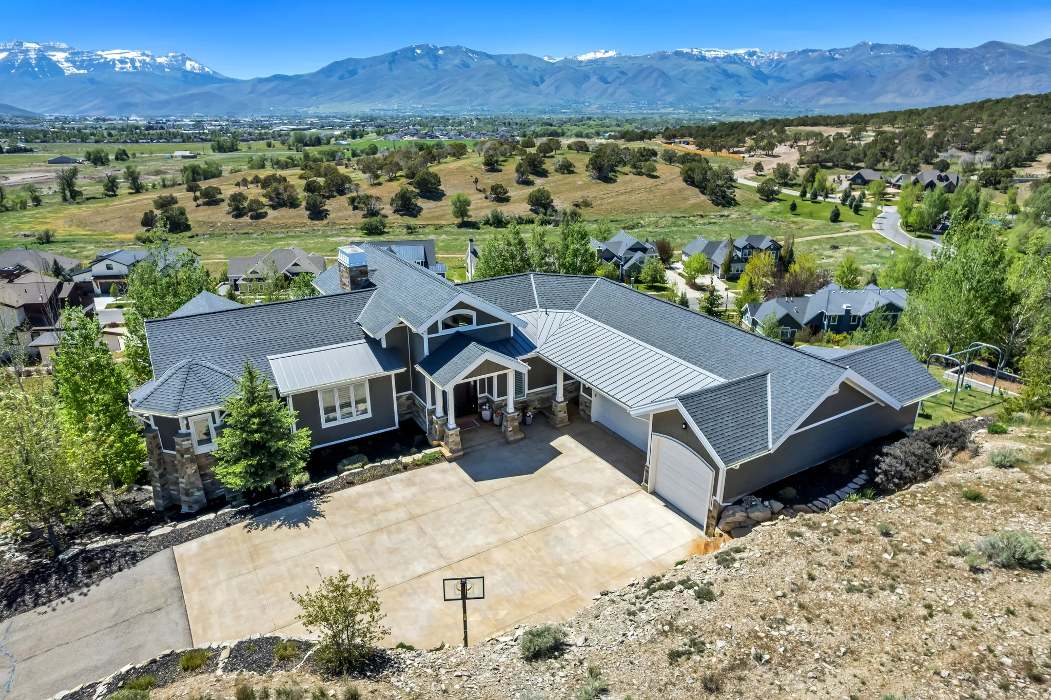 Expansive custom residence featuring a multi-gabled roofline, stone and siding exterior, and an attached two-car garage