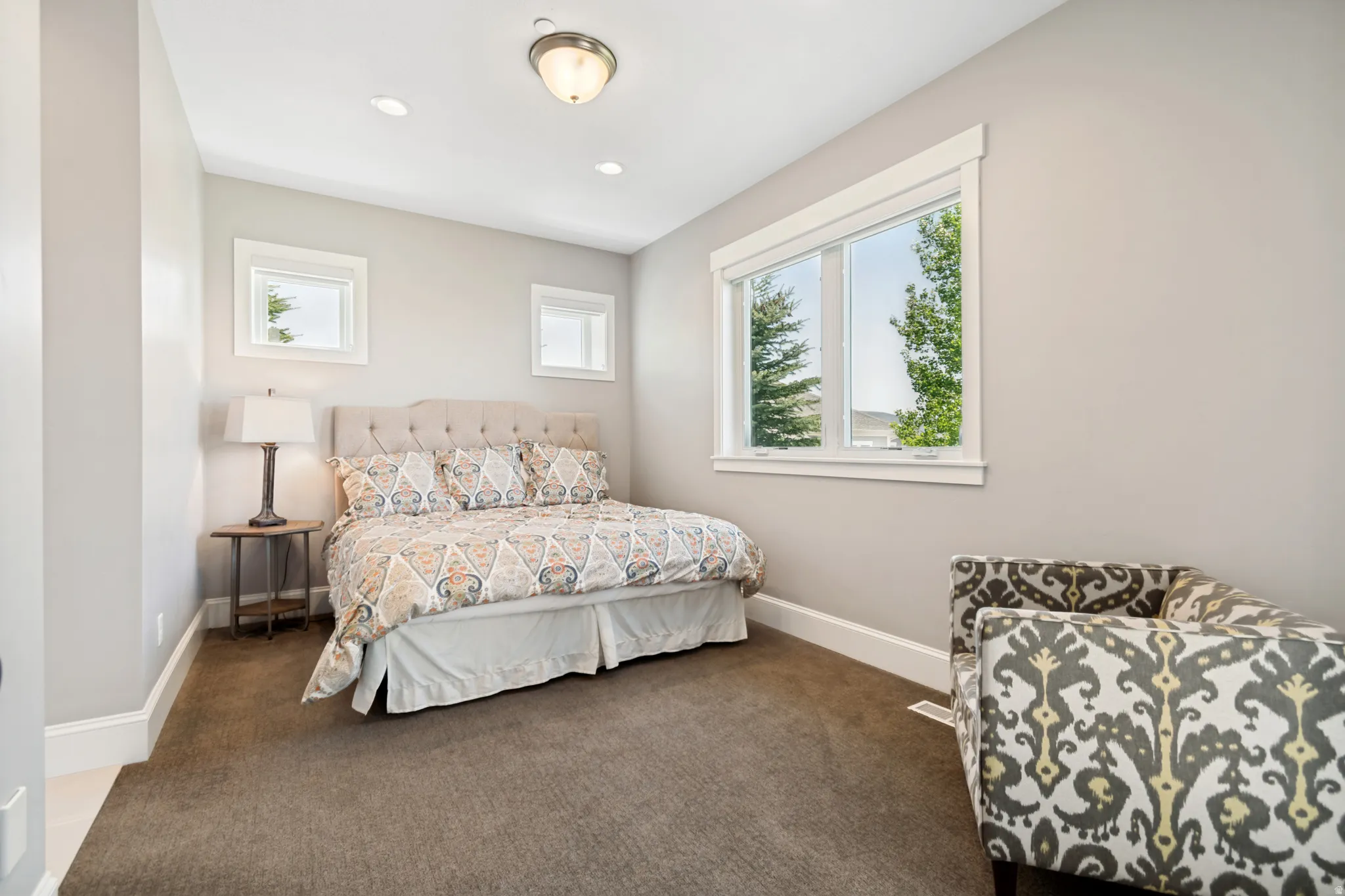 Carpeted room featuring multiple windows with white trim, recessed lighting, and a flush-mount ceiling fixture