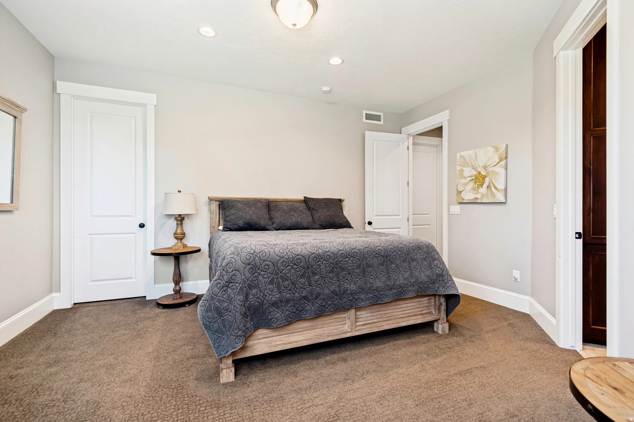Carpeted interior space featuring light-toned walls, white trim, and recessed lighting