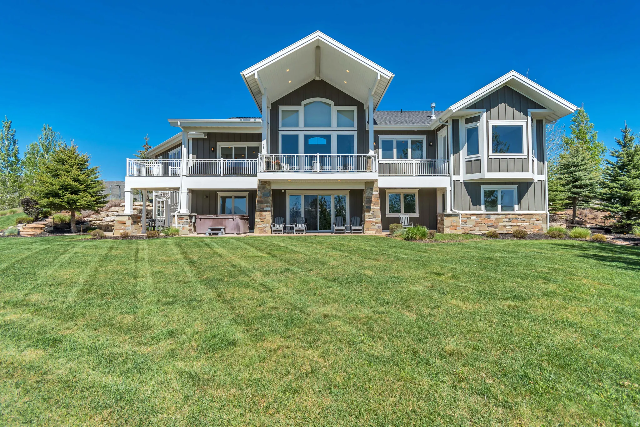 Rear elevation featuring a multi-level design with a spacious lawn