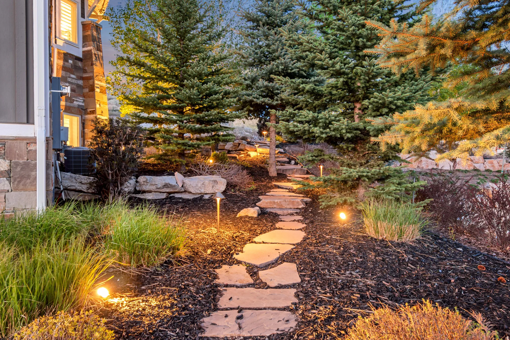 Landscaped pathway featuring natural stone steps and integrated ground lighting