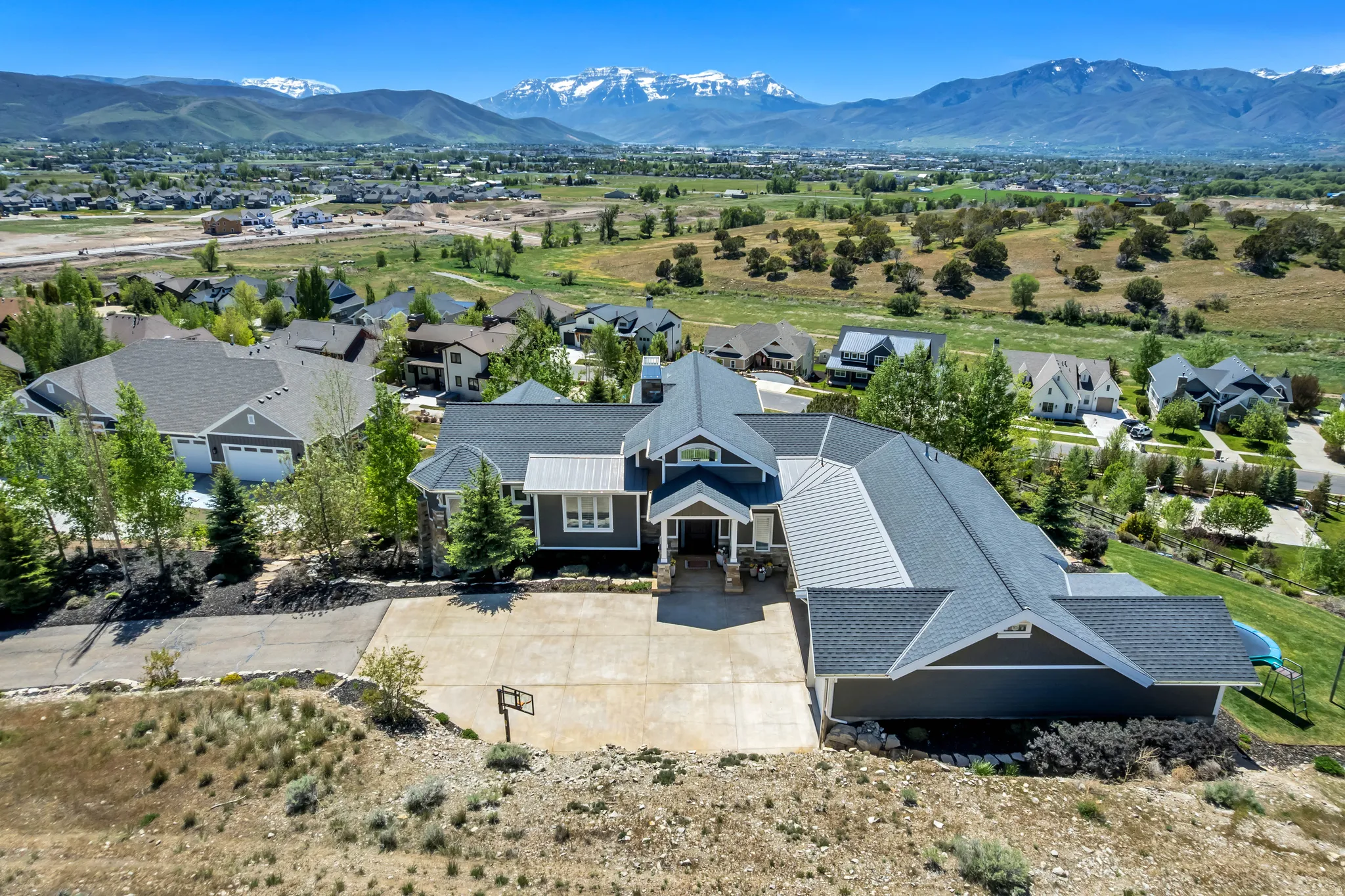 Expansive residential property featuring a multi-gabled roofline and an attached garage with a concrete driveway