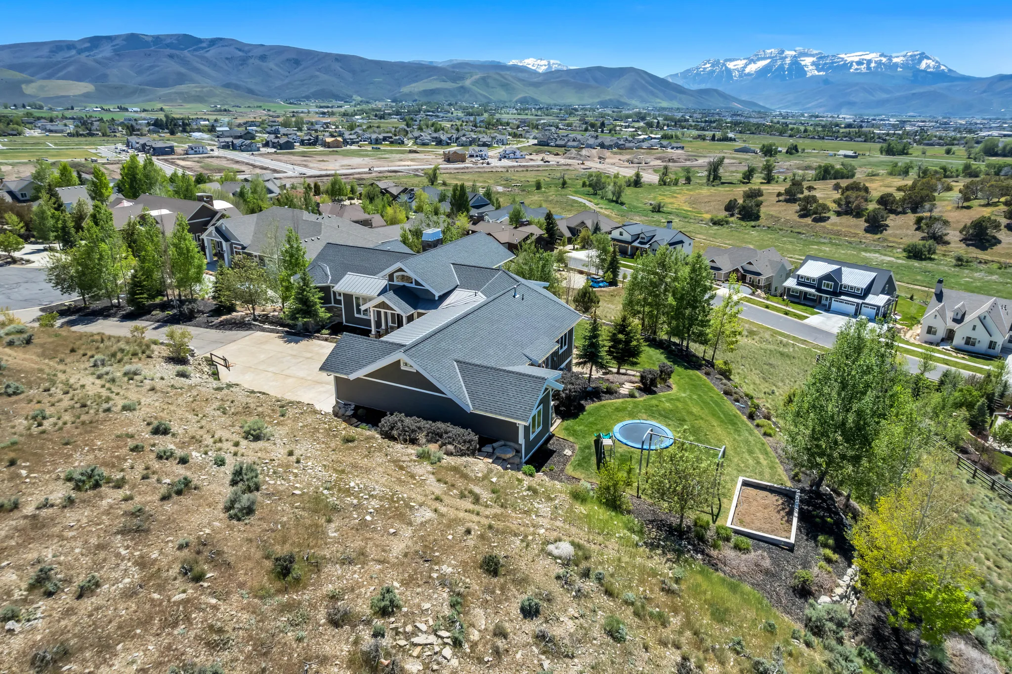 Aerial perspective featuring a modern residence with a dark gray exterior and a shingled roof