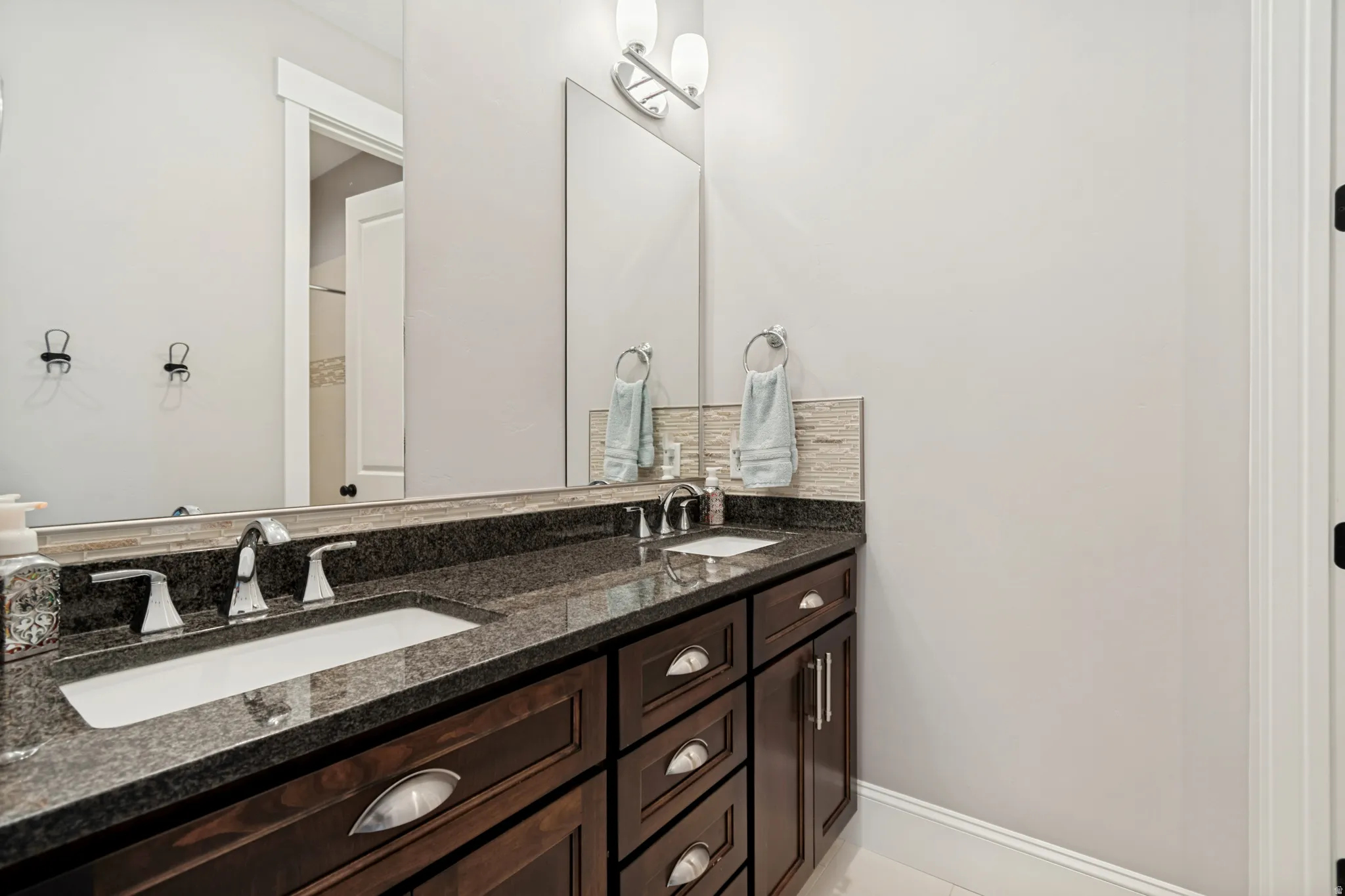 Dual vanity with dark wood cabinetry and polished nickel hardware