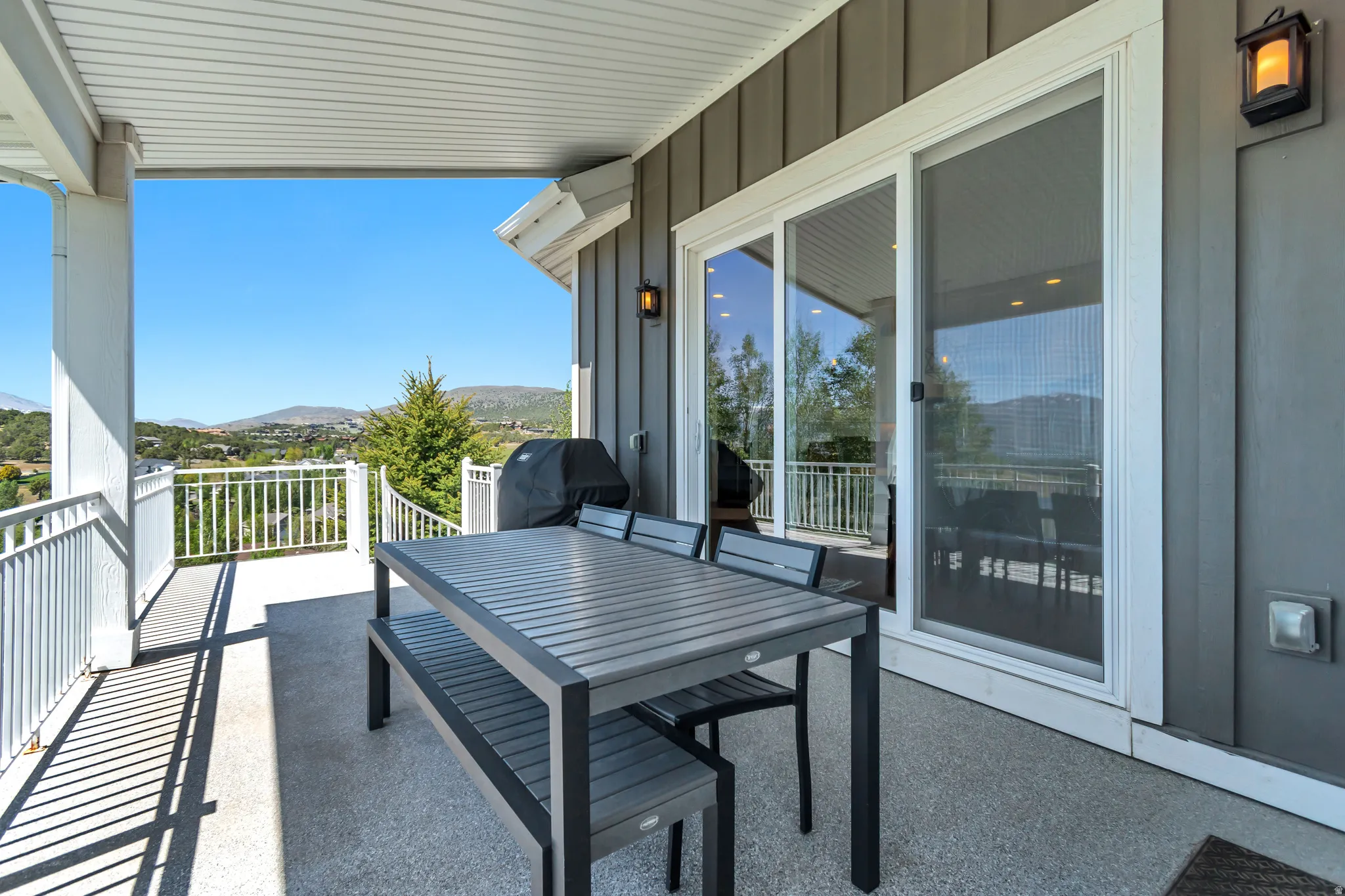 Covered outdoor patio with a textured concrete surface and white railing