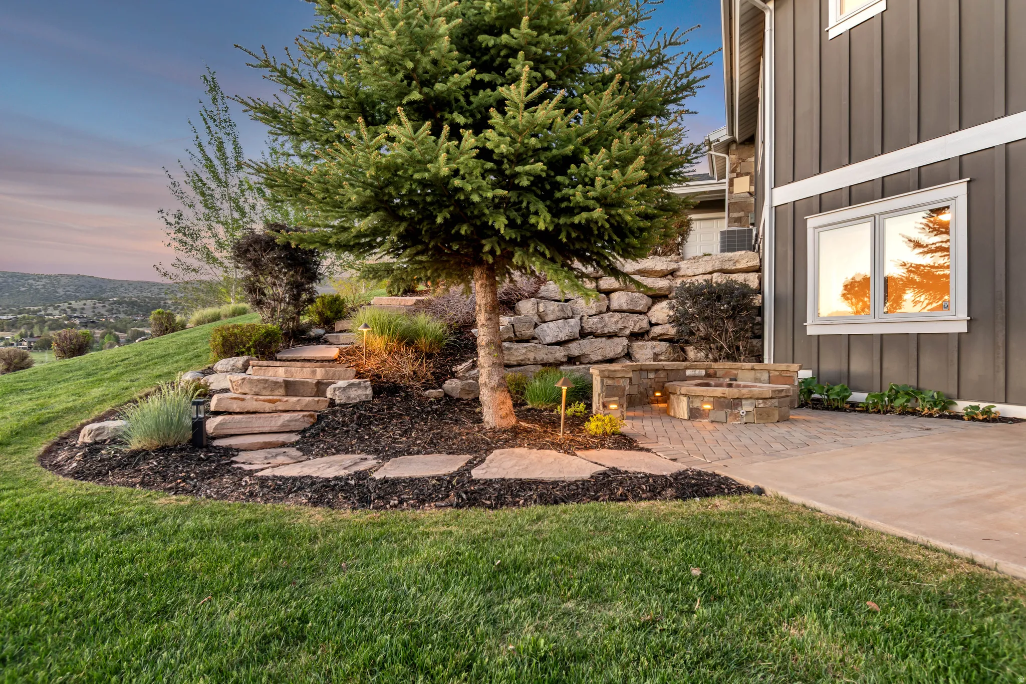 Stone paver patio featuring a built-in fire pit with stone surround