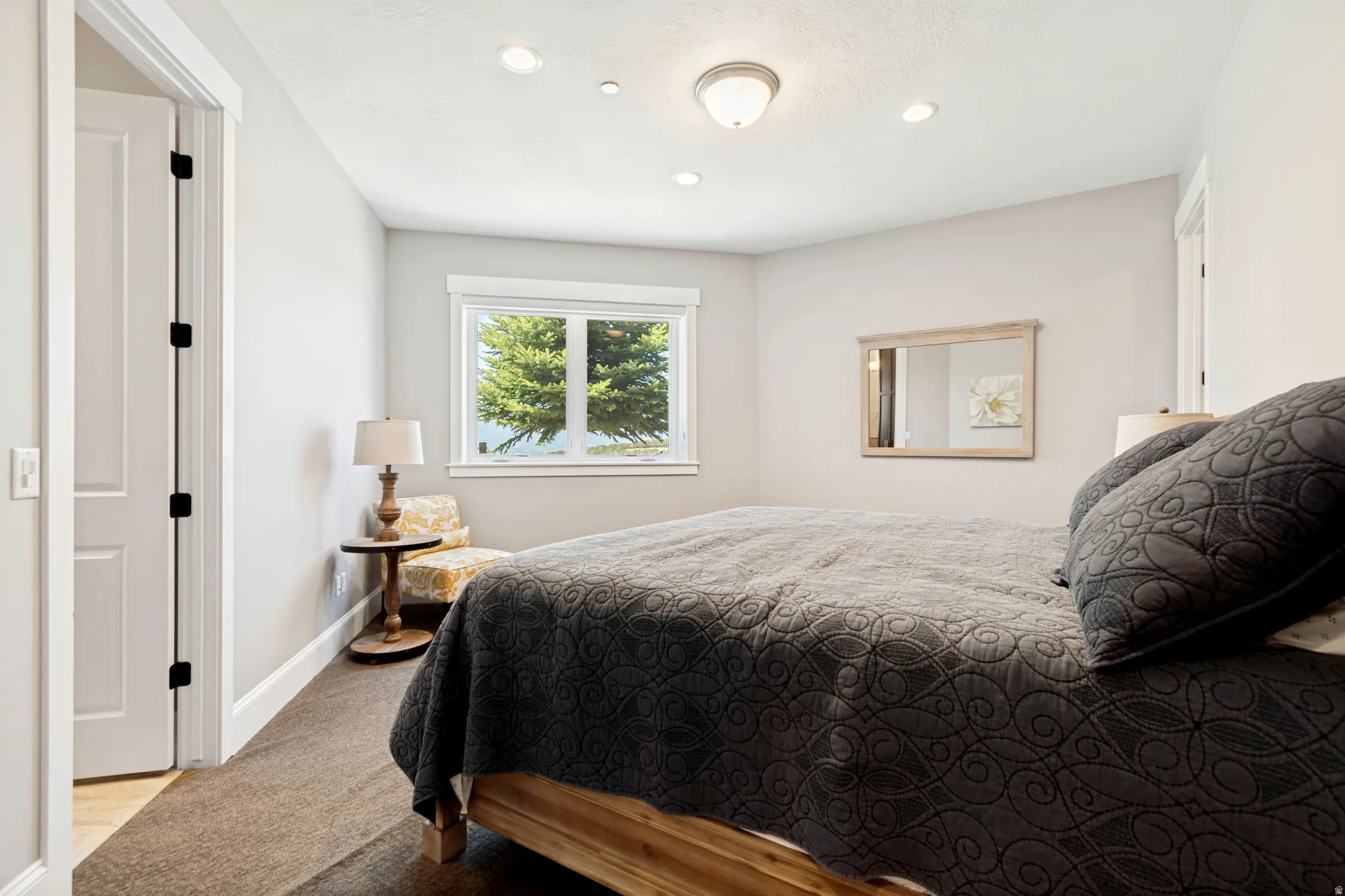 Bedroom featuring light gray walls, brown carpet flooring, and a window with white trim