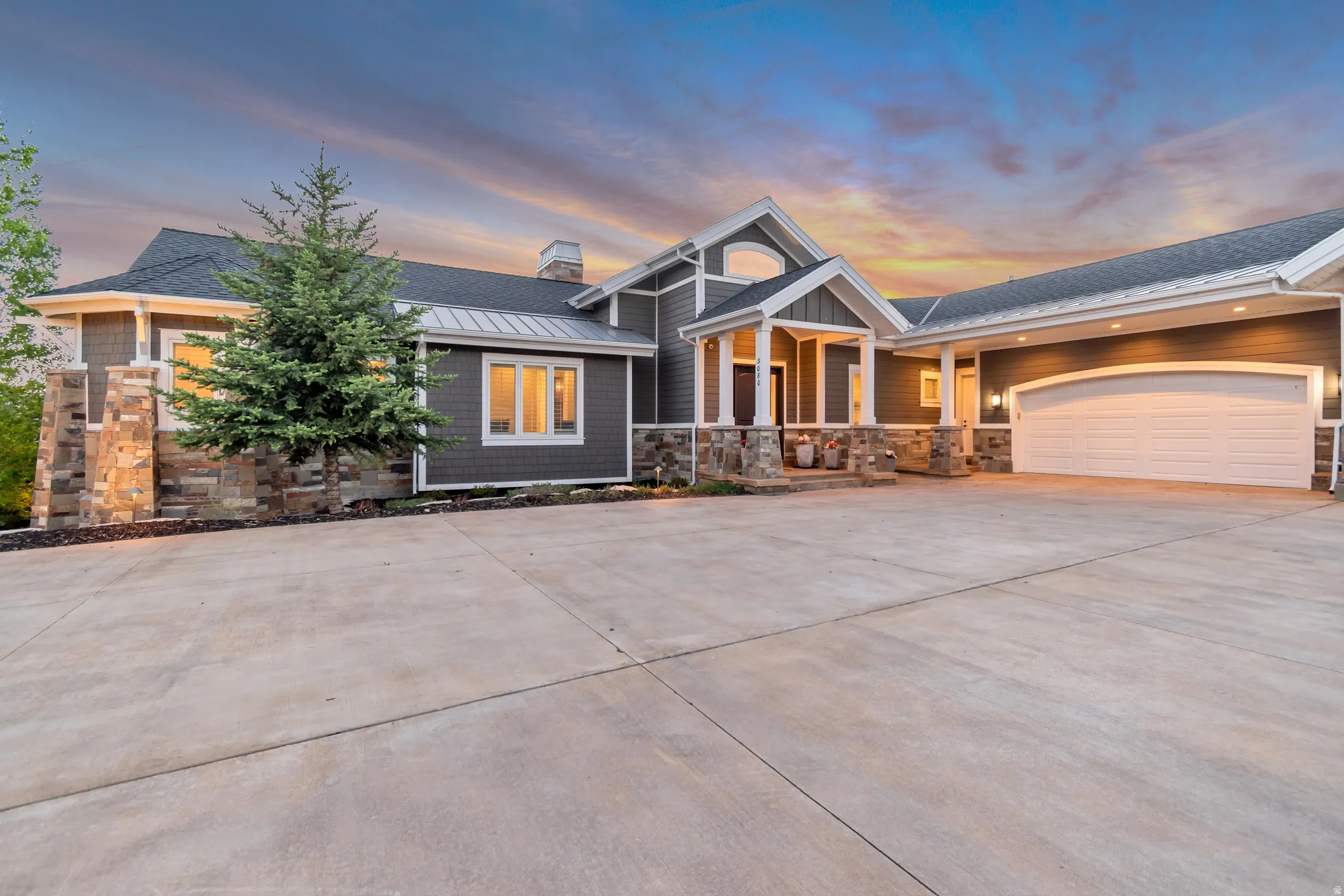 Contemporary-style residence featuring a prominent two-car garage with an arched opening