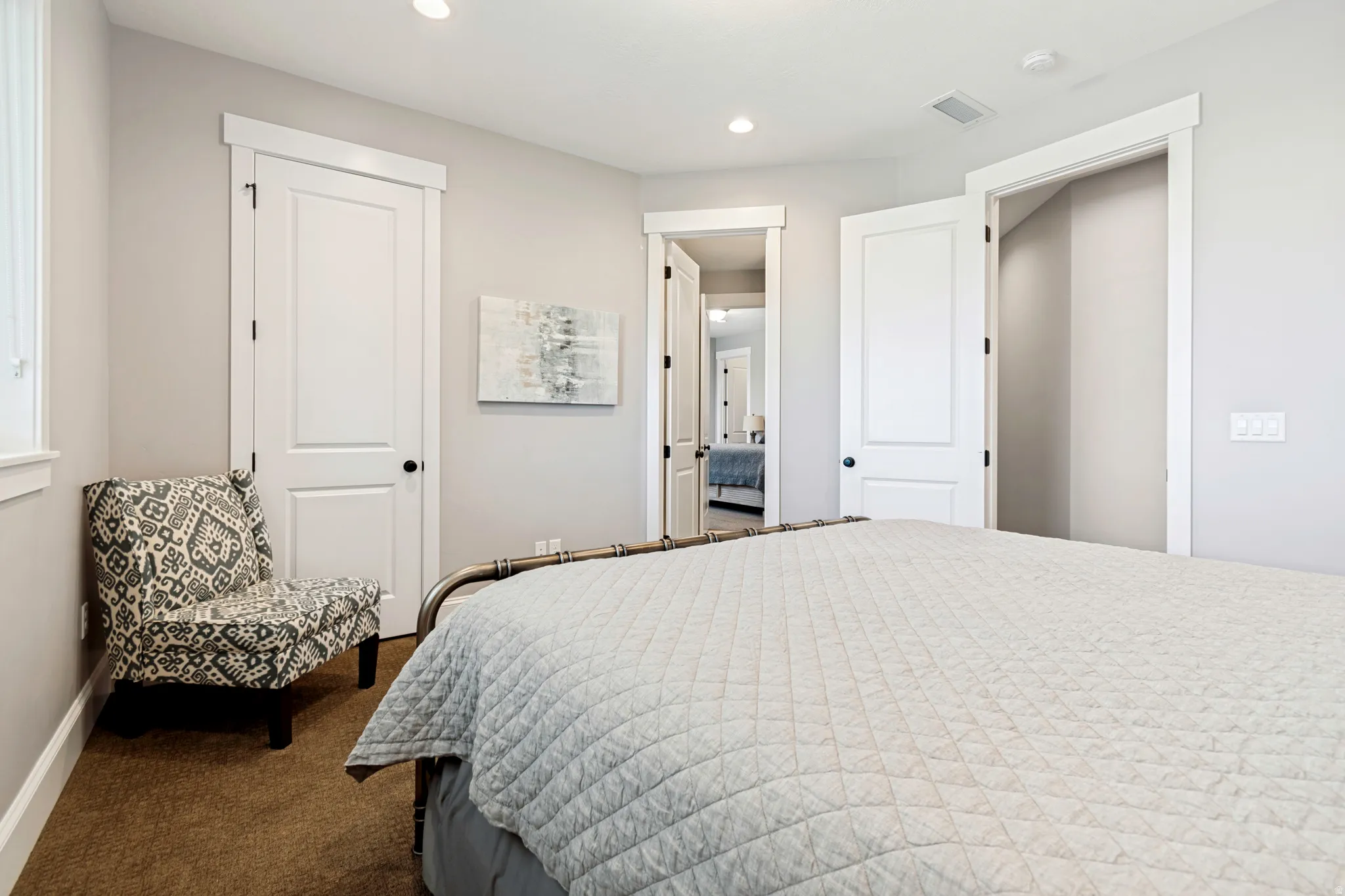 Carpeted interior room featuring recessed lighting, white trim work, and multiple paneled doors