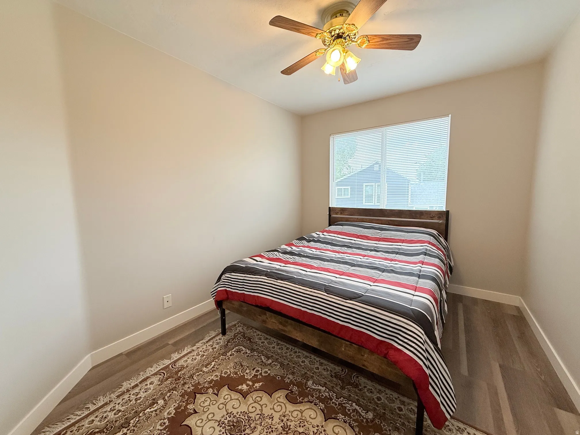 Interior room featuring wood-finish flooring, light neutral wall tones, and white baseboards