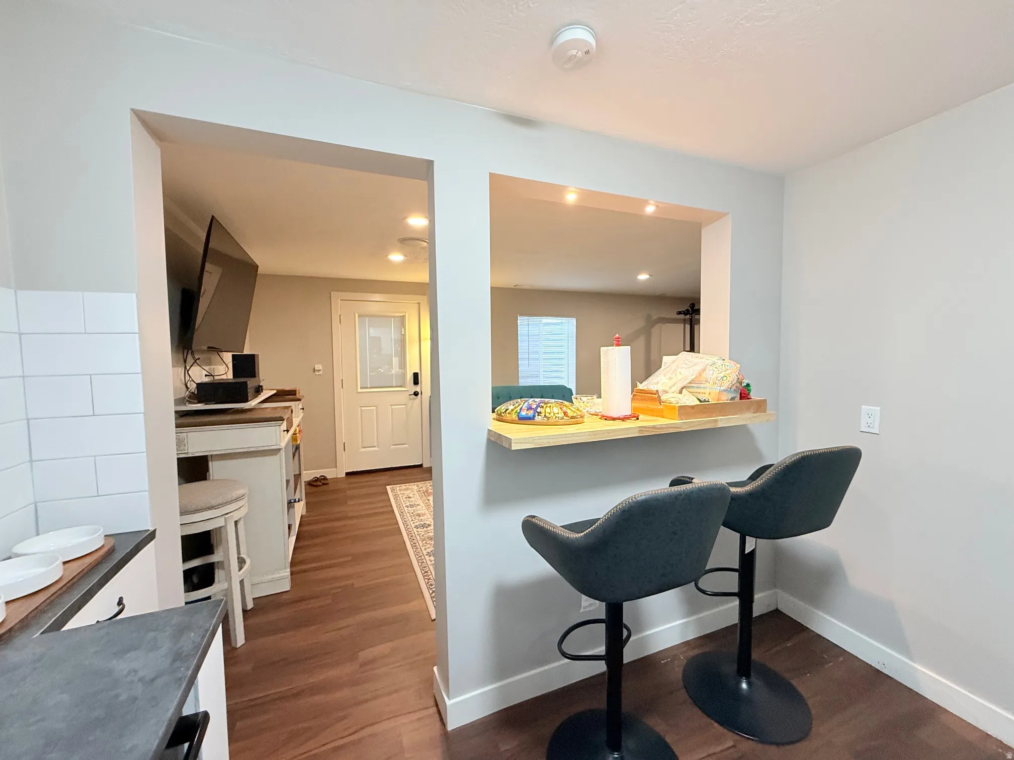 Kitchen passthrough featuring a wood-finish bar top with recessed lighting