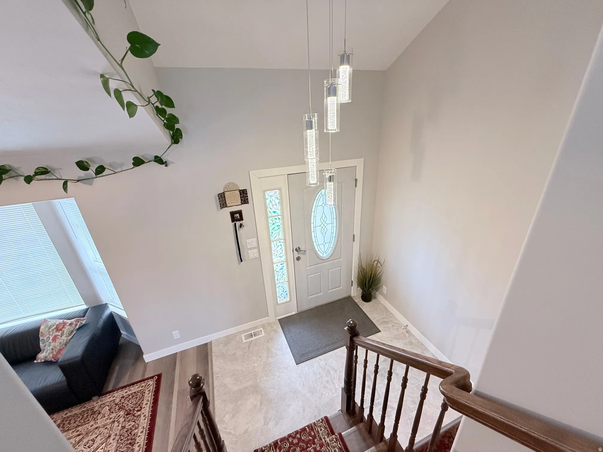 Entryway featuring a decorative glass-insert door, pendant lighting, and a neutral color palette
