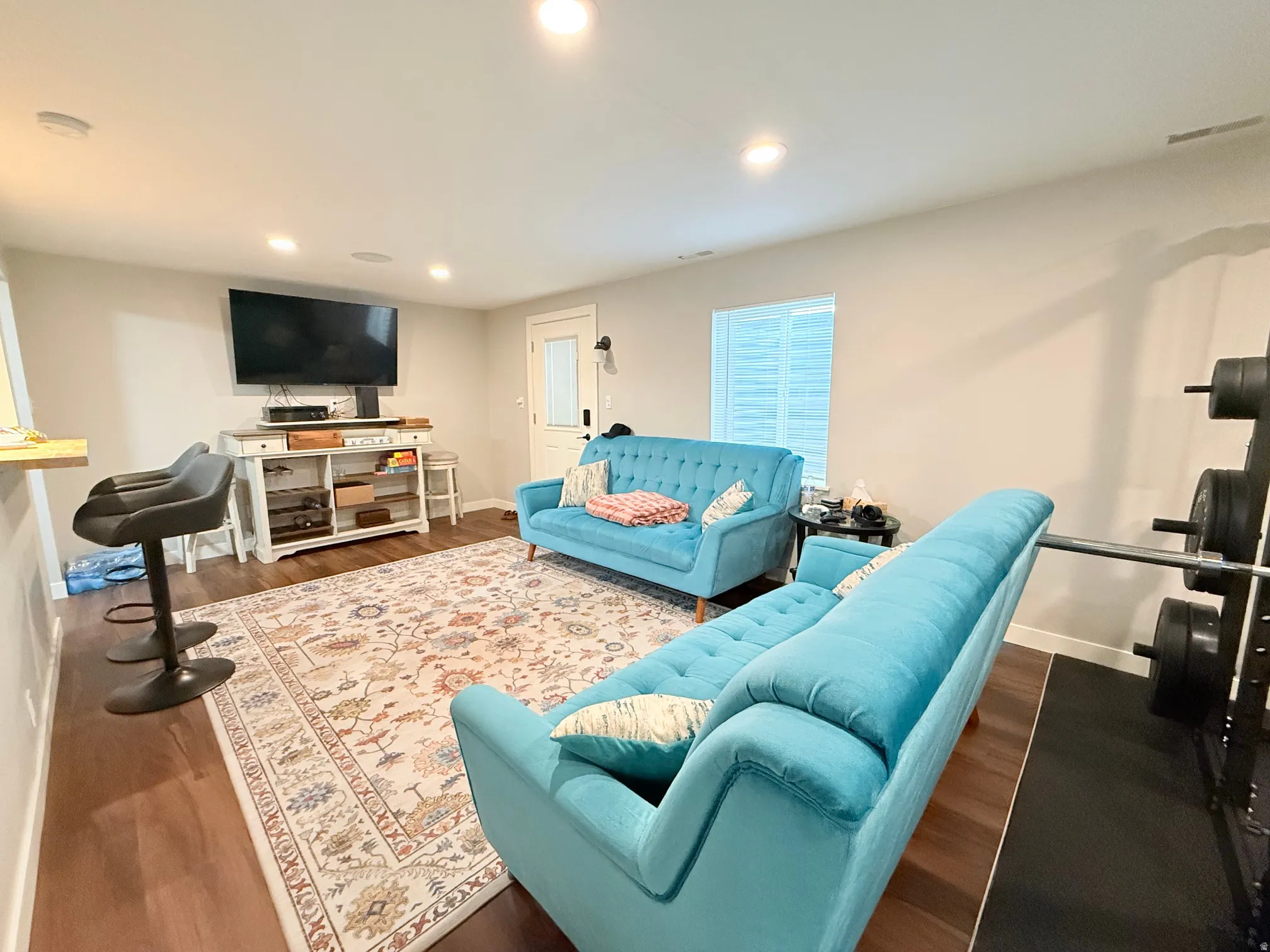 Spacious room featuring wood-finish flooring, recessed lighting, and light-toned walls